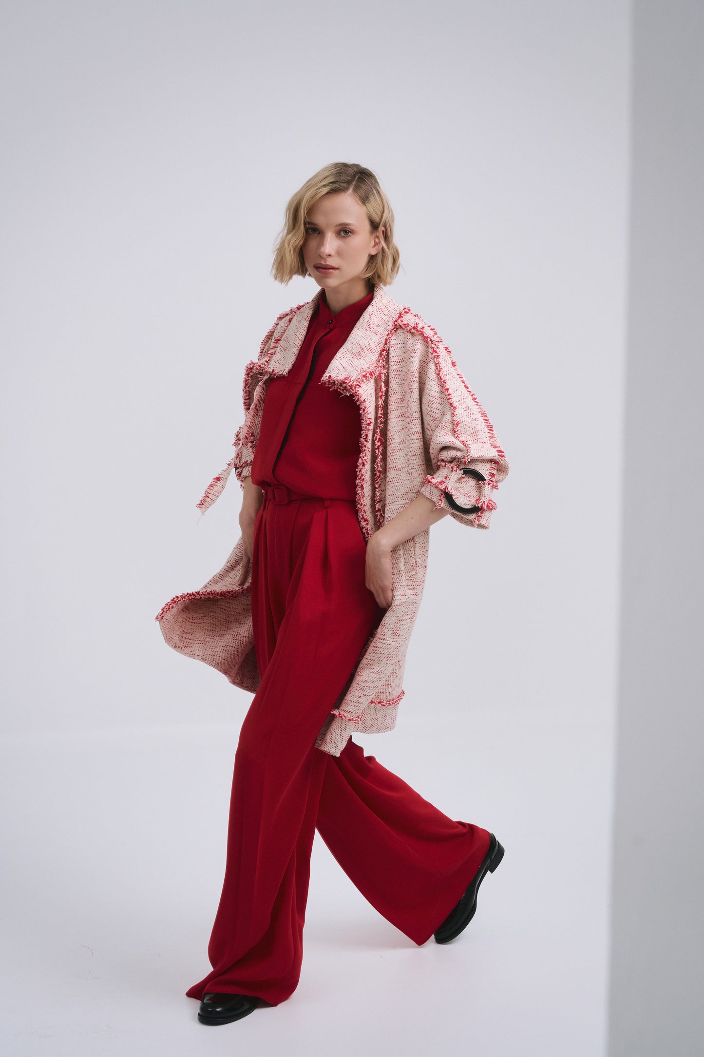 Model wears the Amelia Toro Compact Cotton Coat with Fringe Detail in Red/Beige, front view