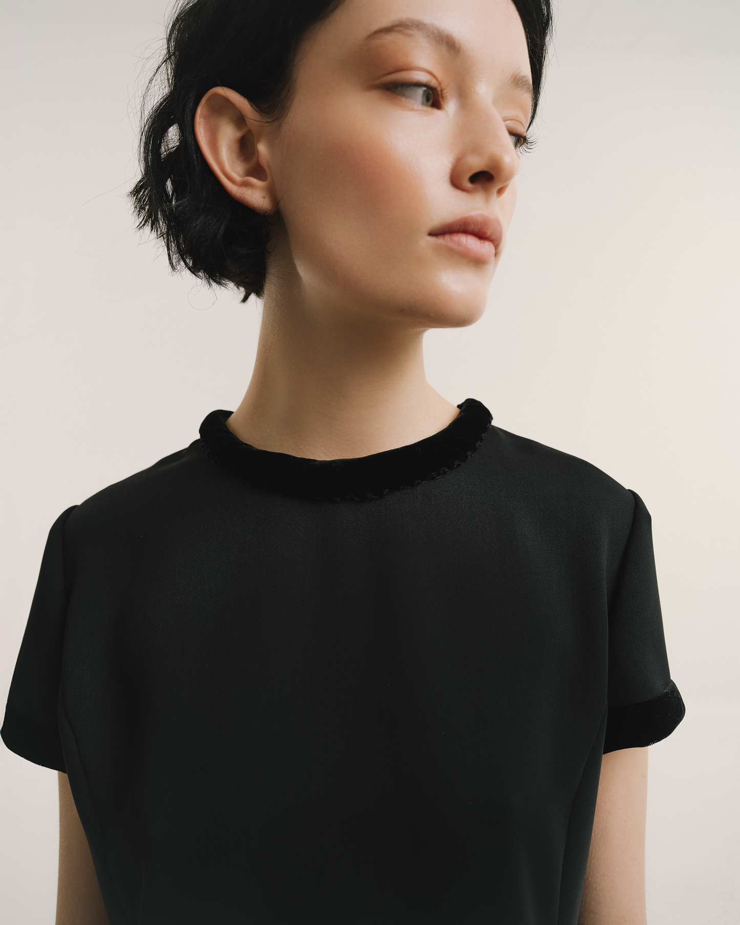 Model wears the Amelia Toro Velvet-Trimmed Little Black Dress in black, front view