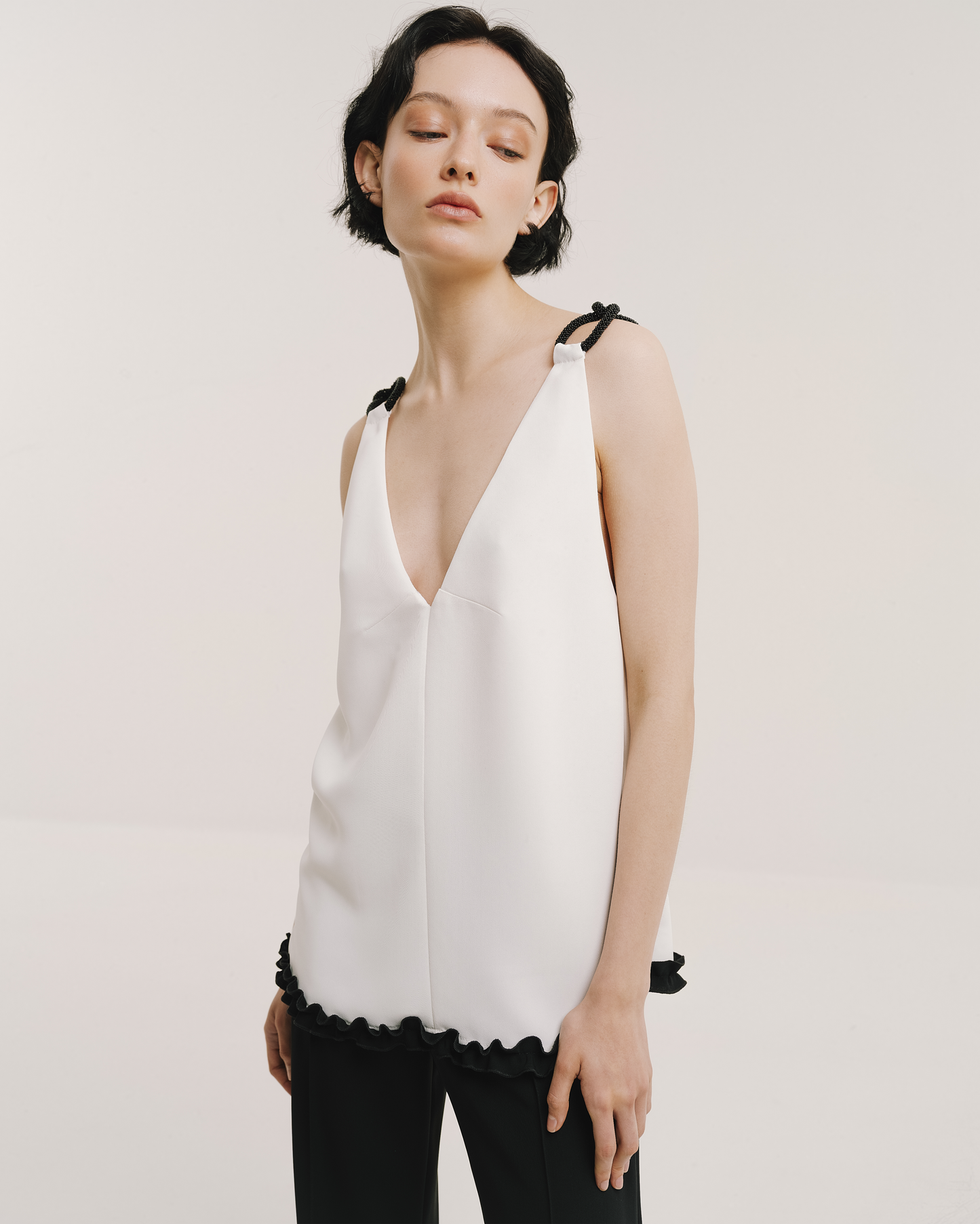 Model wears the Amelia Toro 1920s-Inspired Sleeveless Top in white, front view