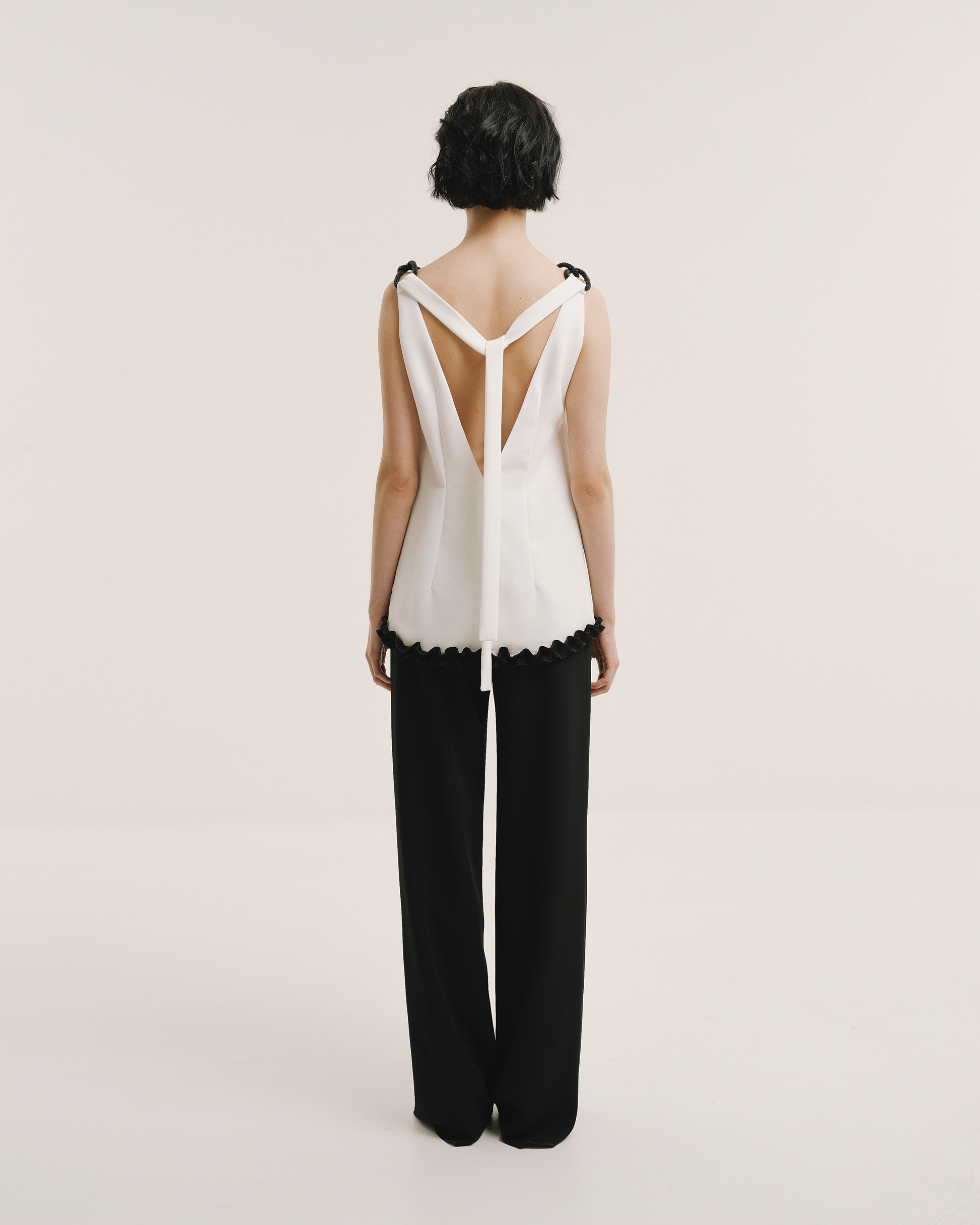 Model wears the Amelia Toro 1920s-Inspired Sleeveless Top in white, front view