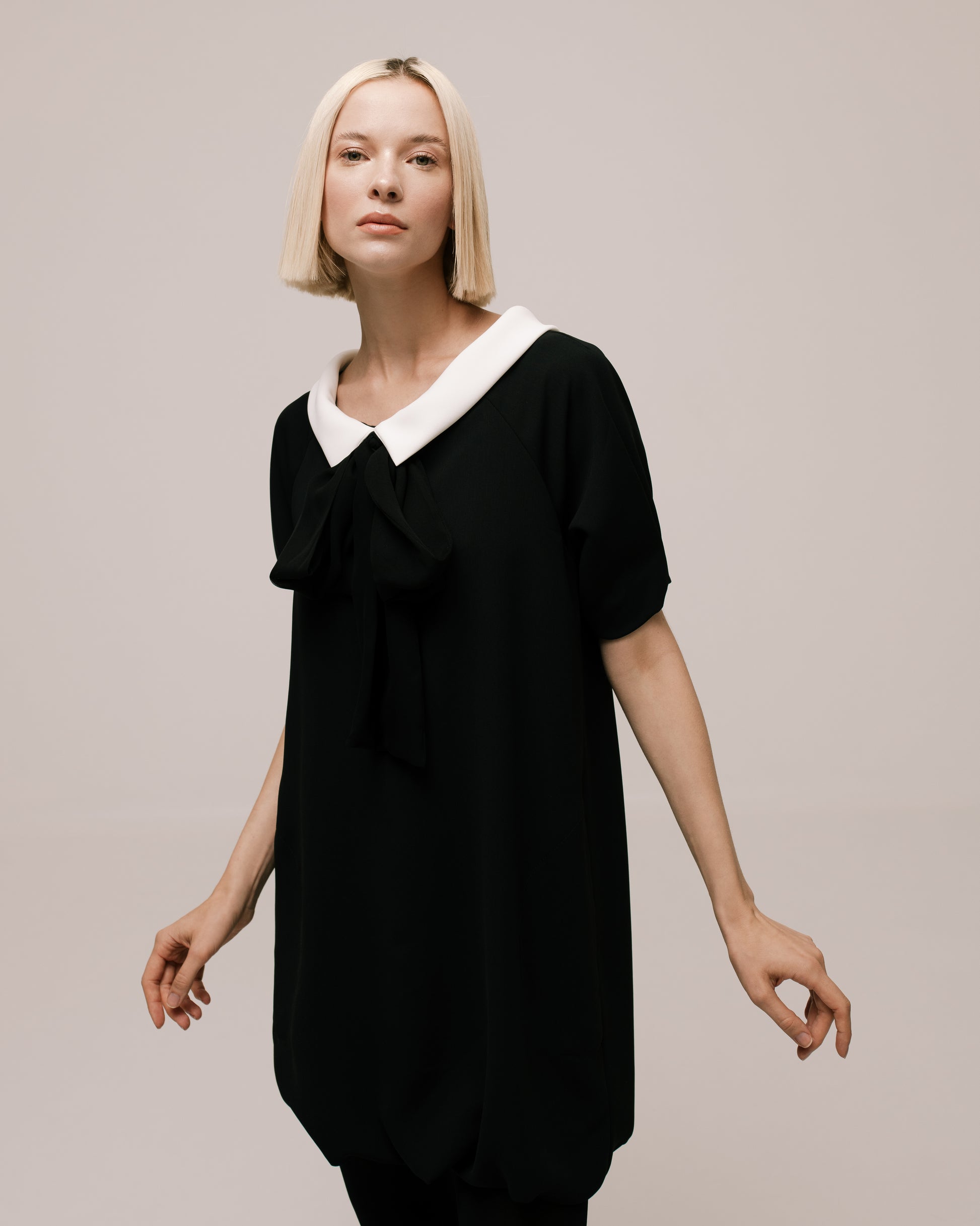 Side view of the Amelia Toro Bateau-Collar Bow-Tie Cady Mini Dress in Black