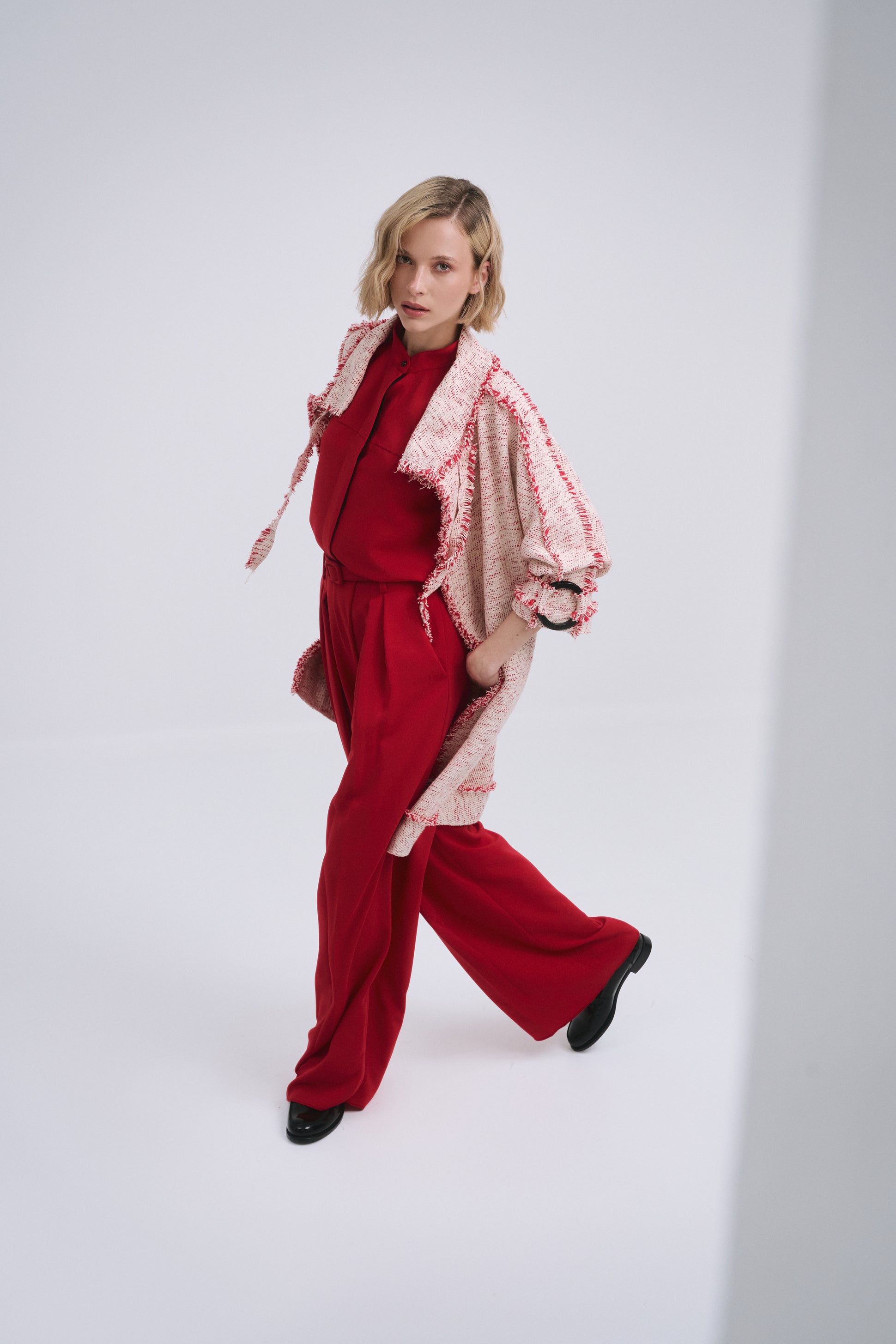 Model wears the Amelia Toro Compact Cotton Coat with Fringe Detail in Red/Beige, front view
