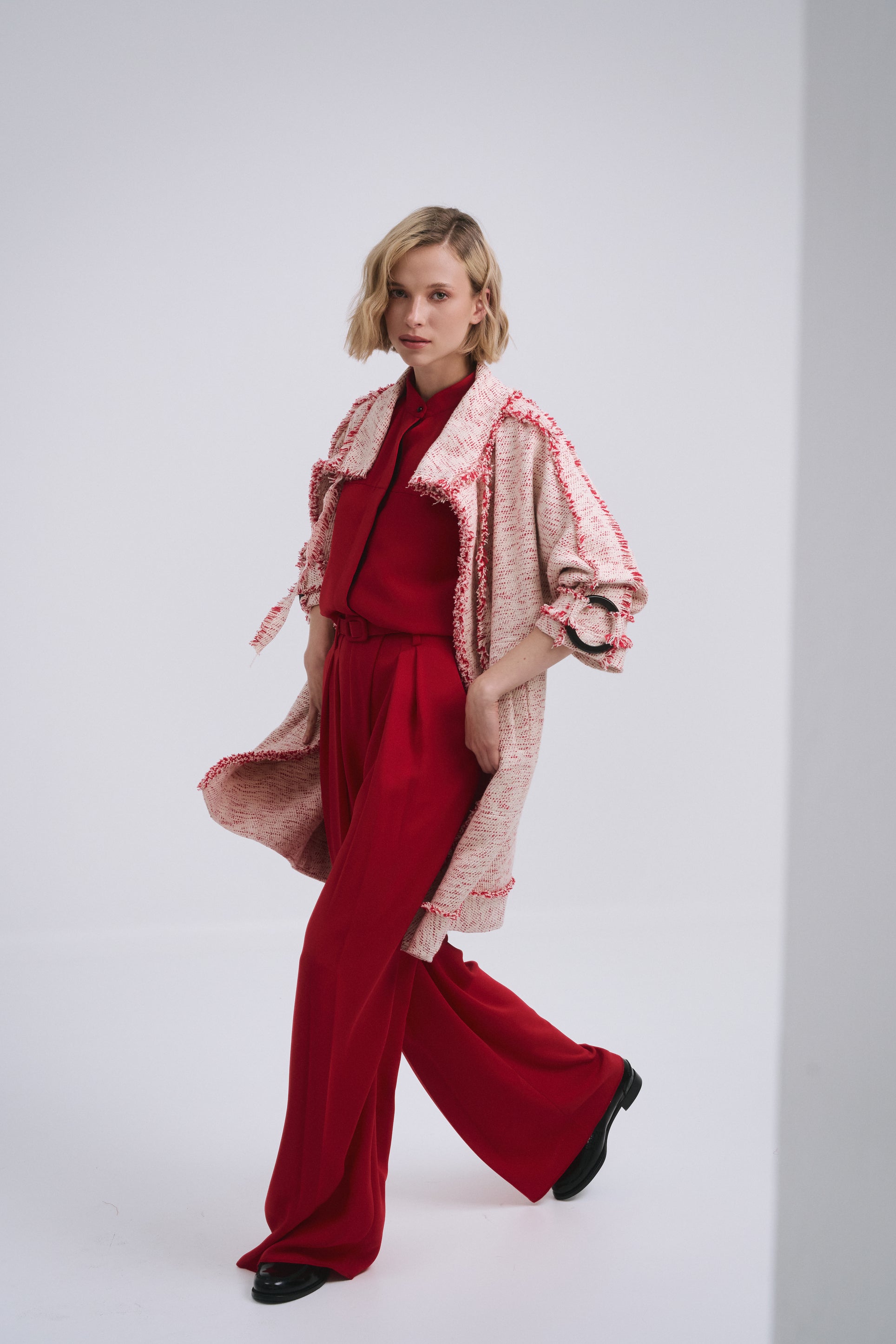 Model wears the Amelia Toro Compact Cotton Coat with Fringe Detail in Red/Beige, front view