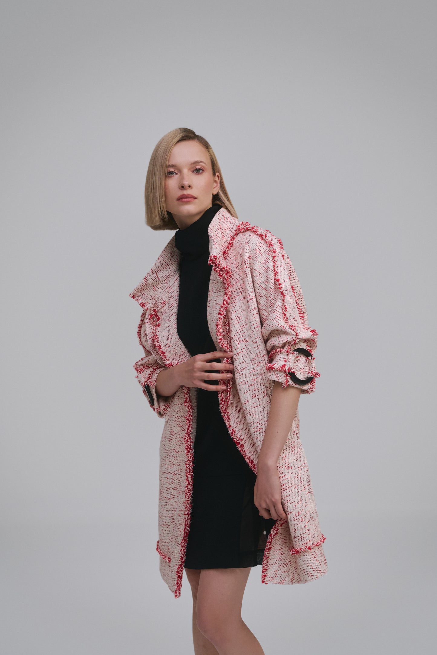 Model wears the Amelia Toro Compact Cotton Coat with Fringe Detail in Red/Beige, front view