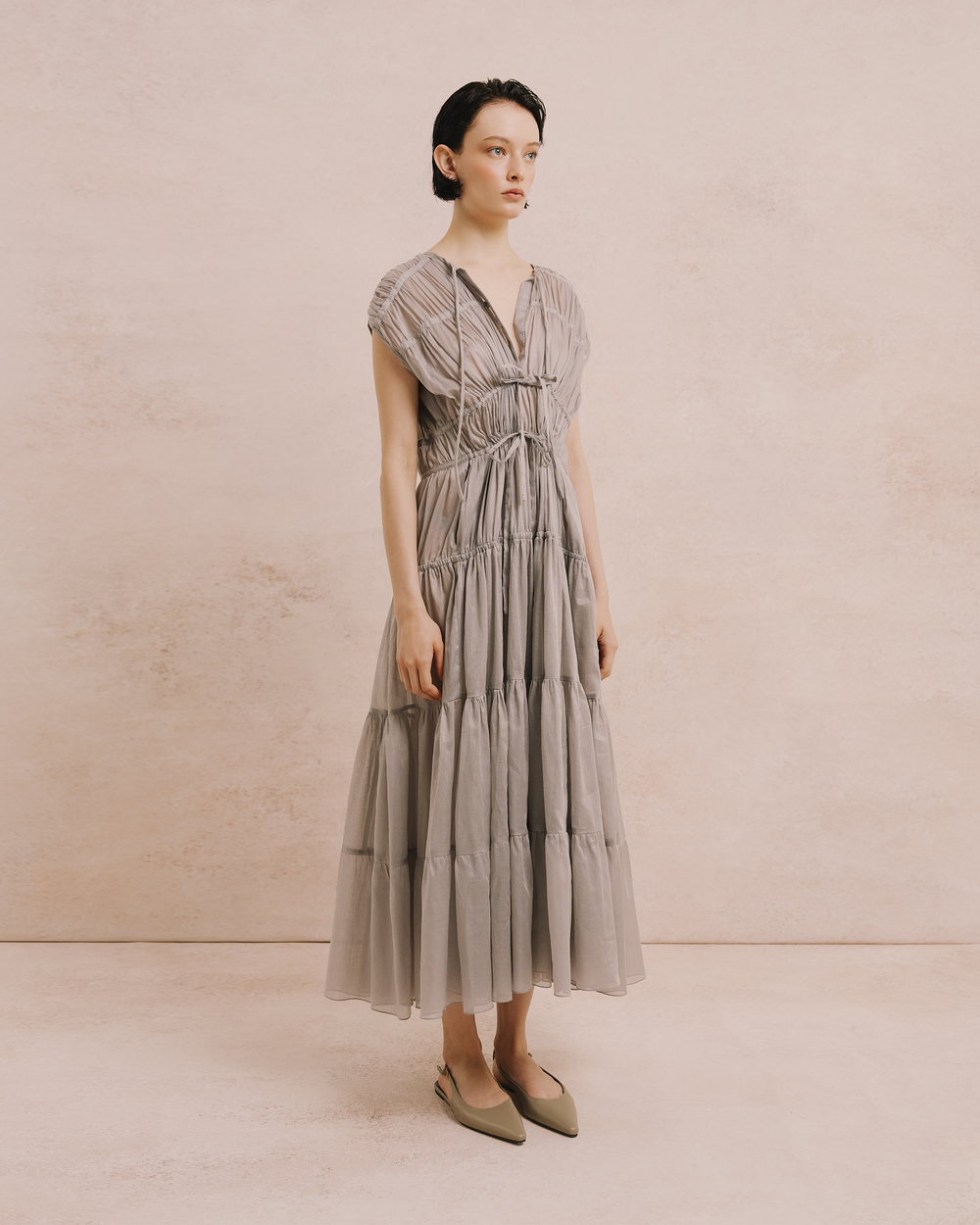 Model wears the Amelia Toro Cotton Voile Tiered Maxi Dress in grey, front view