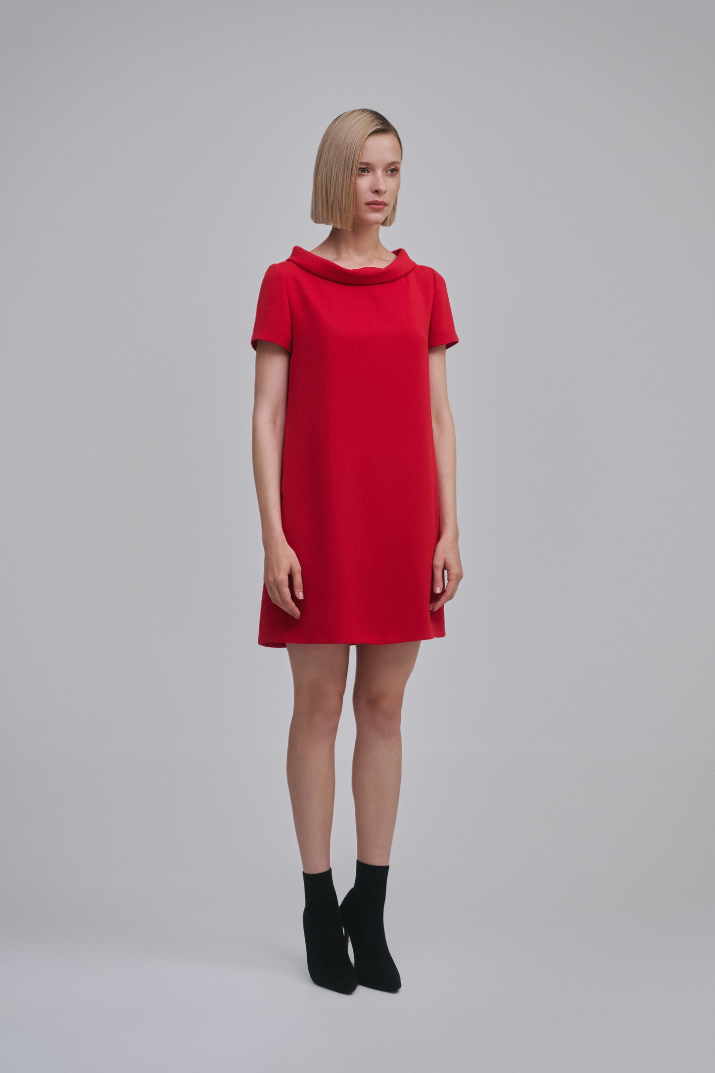Model wears the Amelia Toro Cowl-Collar Short-Sleeve Mini Dress in Red, front view