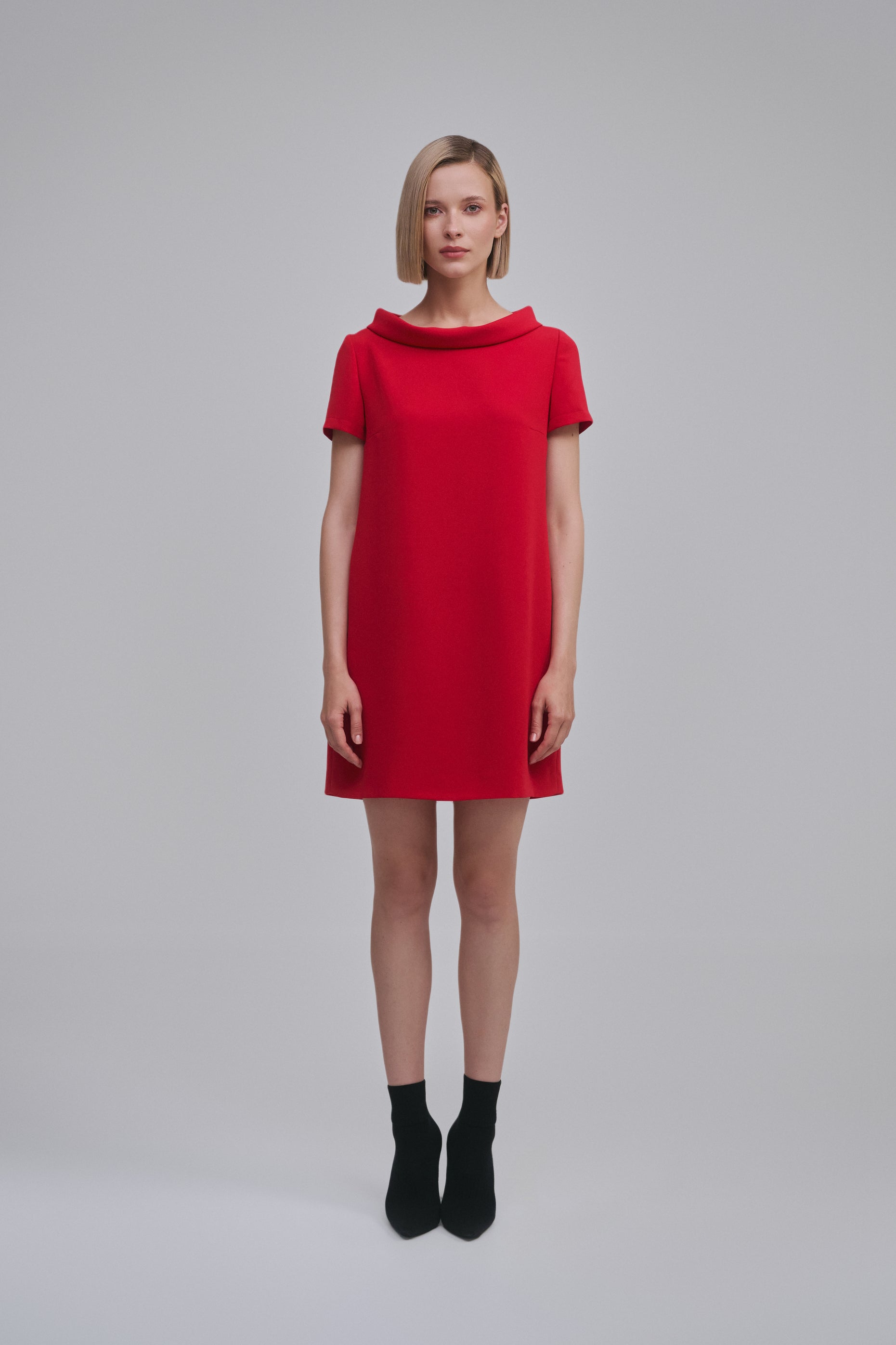 Model wears the Amelia Toro Cowl-Collar Short-Sleeve Mini Dress in Red, front view