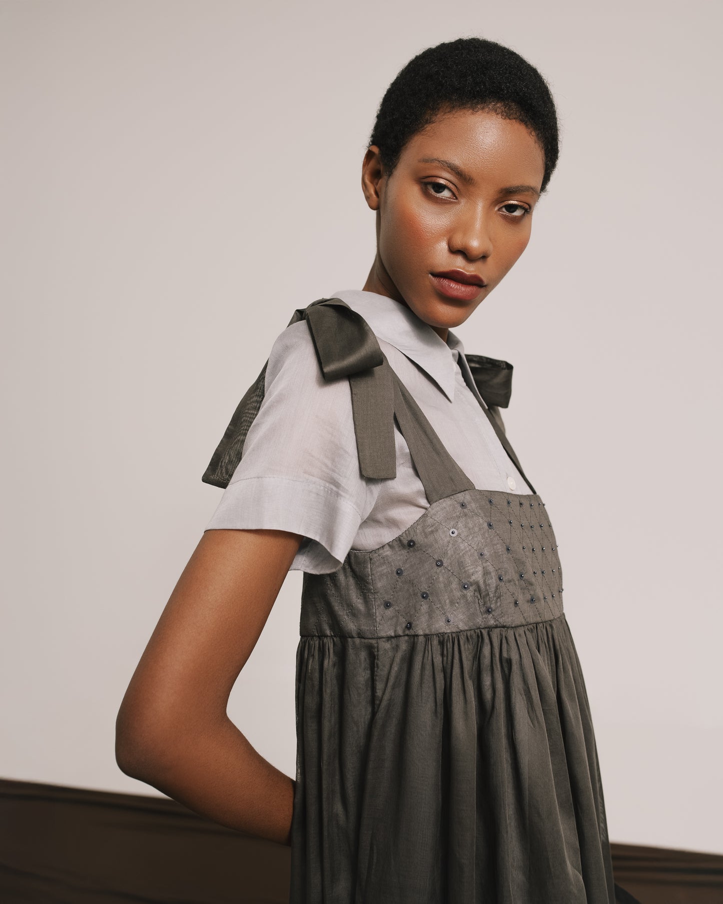 Model wears the Amelia Toro Embroidered Cotton Voile Midi Sundress in Grey/Pink, front view