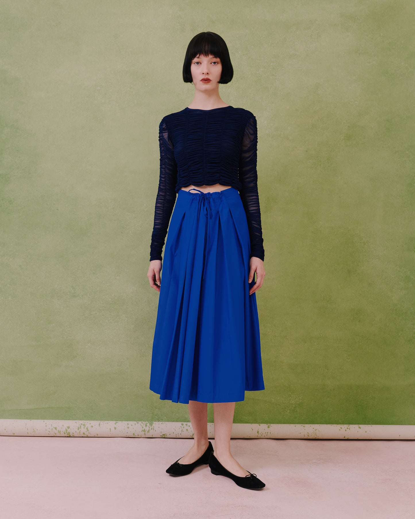 Model wears the Amelia Toro Gathered-Waist Pleated Midi Skirt in royal blue, front view