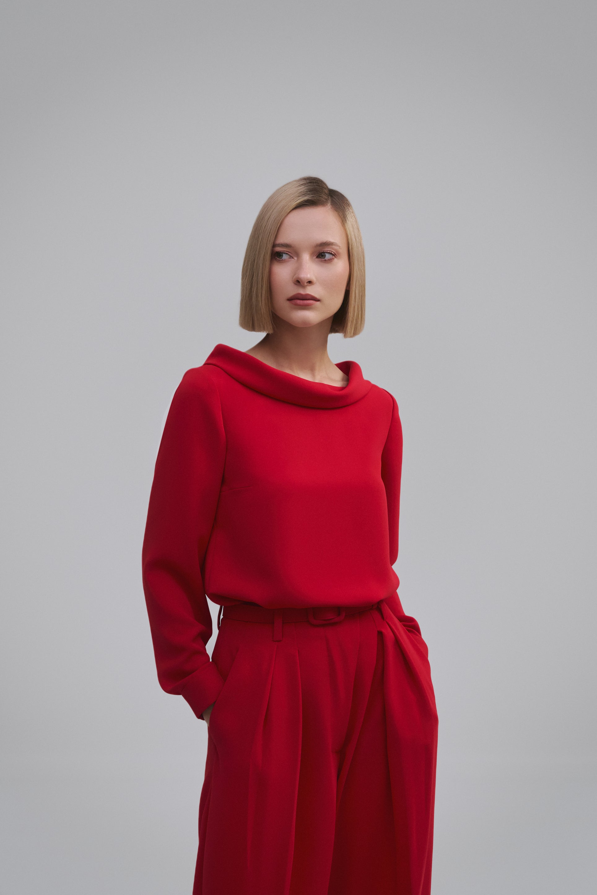 Model wears the Amelia Toro High-Neck Long-Sleeve Cady Blouse in Red, front view