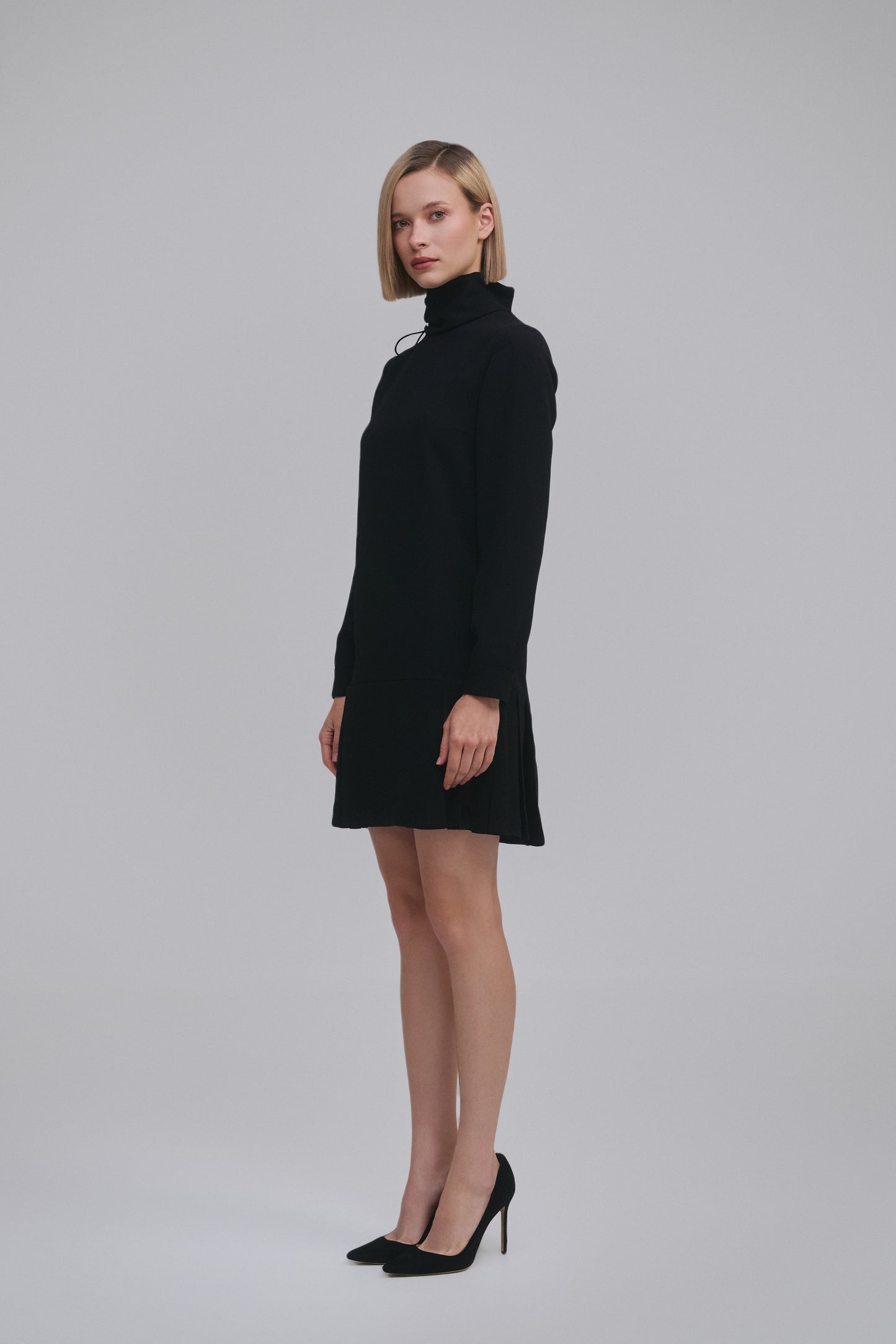 Model wears the Amelia Toro Long-Sleeve Pleated Chiffon Mini Dress in Black, front view
