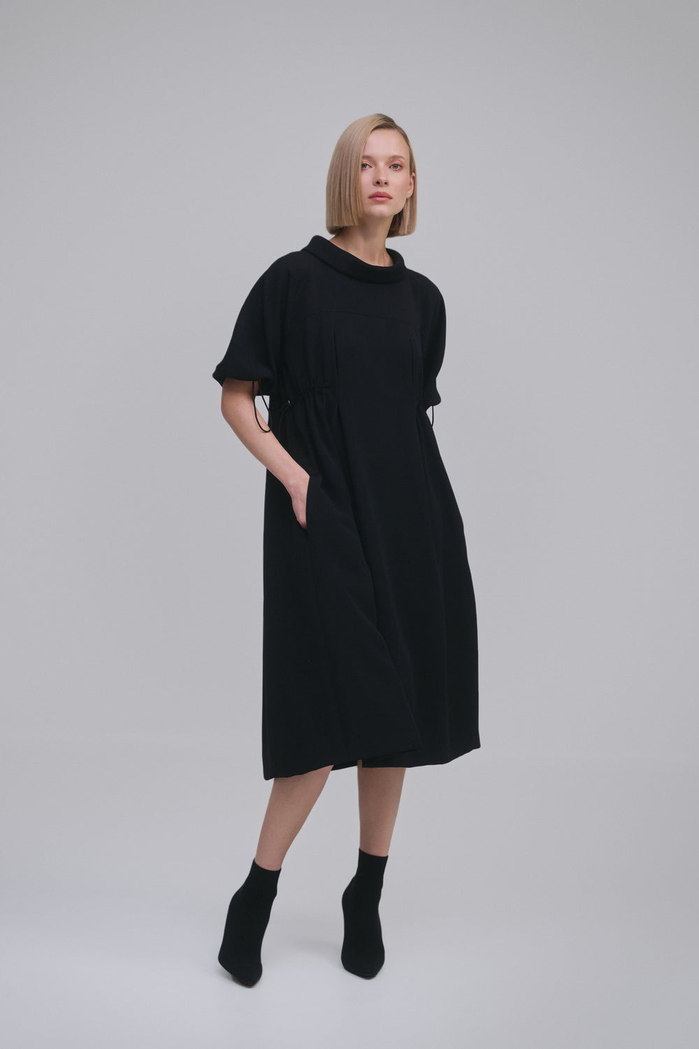 Model wears the Amelia Toro Loose Cowl-Neck Kimono-Sleeve Midi Dress in Black, front view