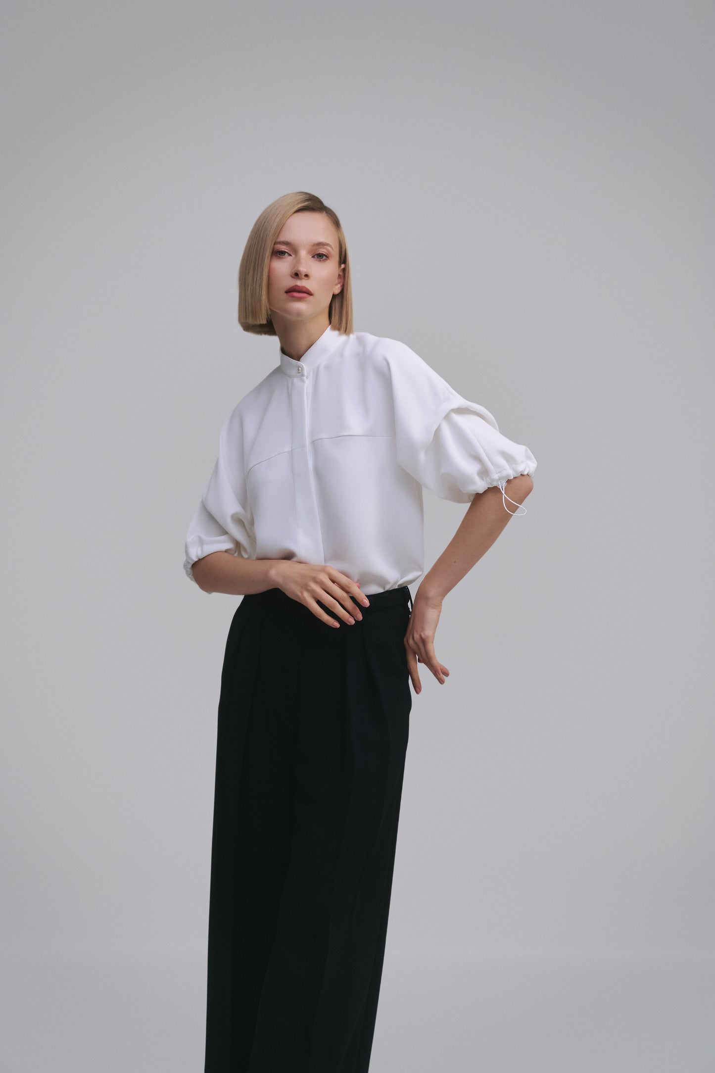 Model wears the Amelia Toro Nehru-Collar Kimono-Sleeve Blouse in White, front view