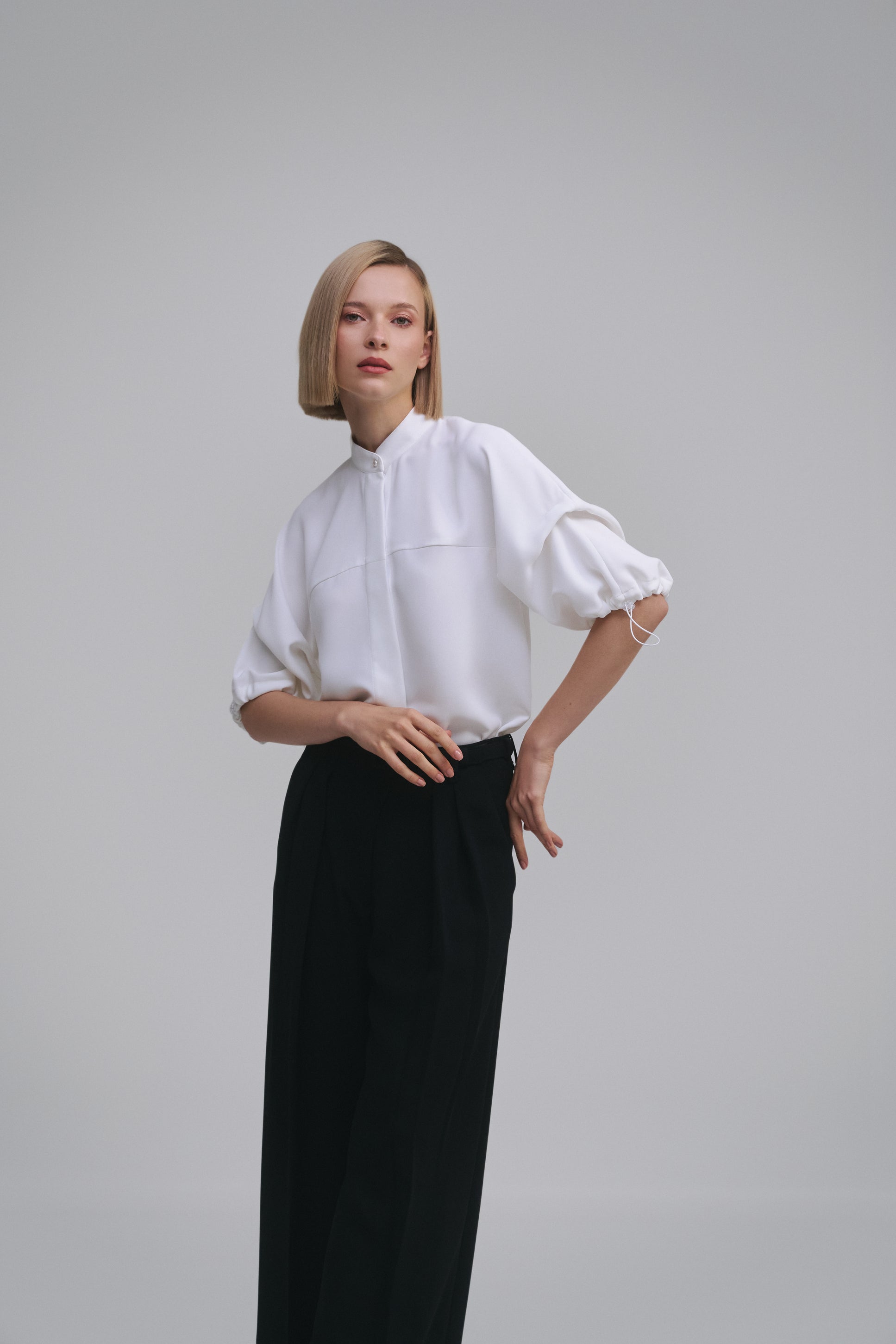 Model wears the Amelia Toro Nehru-Collar Kimono-Sleeve Blouse in White, front view