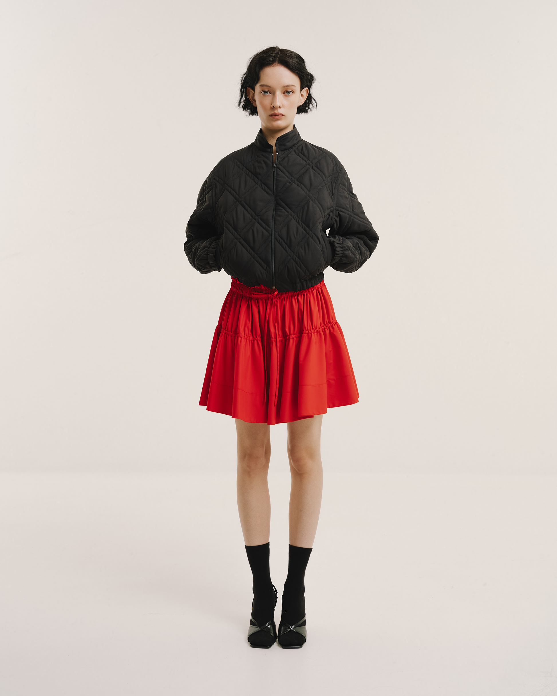 Model wears the Amelia Toro Quilted Cropped Bomber Jacket in black, front view