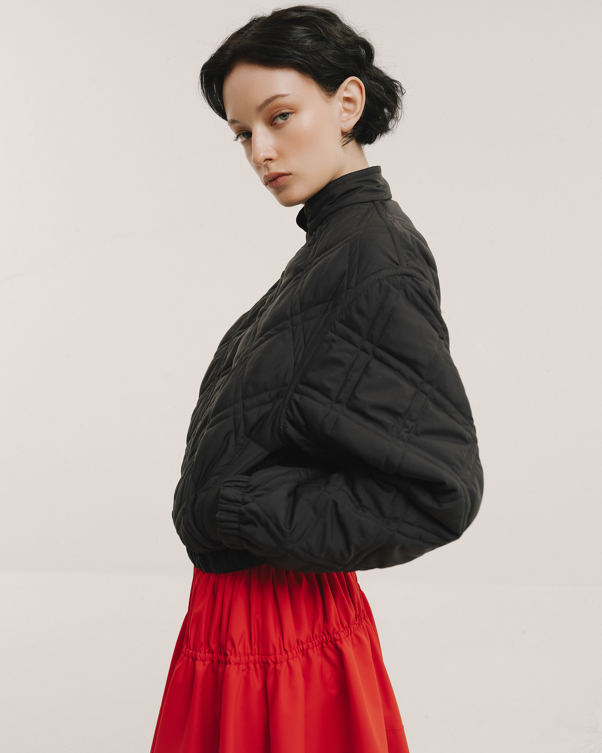 Model wears the Amelia Toro Quilted Cropped Bomber Jacket in red, front view
