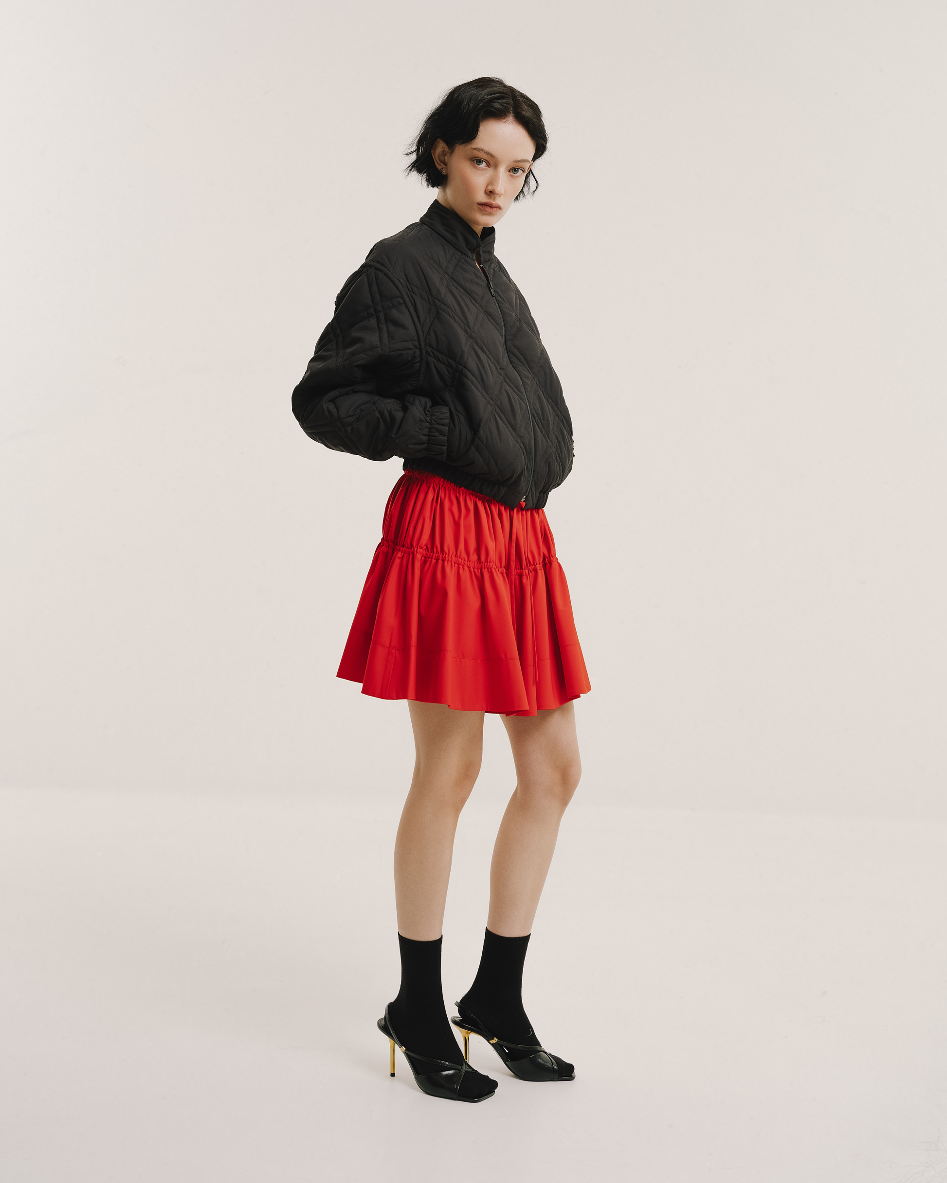 Model wears the Amelia Toro Quilted Cropped Bomber Jacket in teal green, front view