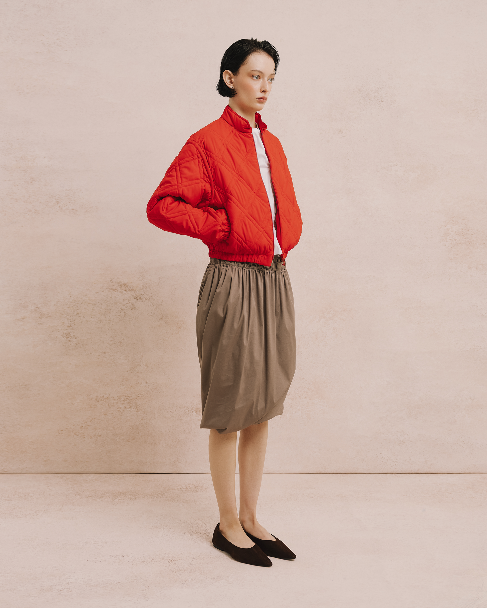 Model wears the Amelia Toro Quilted Cropped Bomber Jacket in teal green, front view