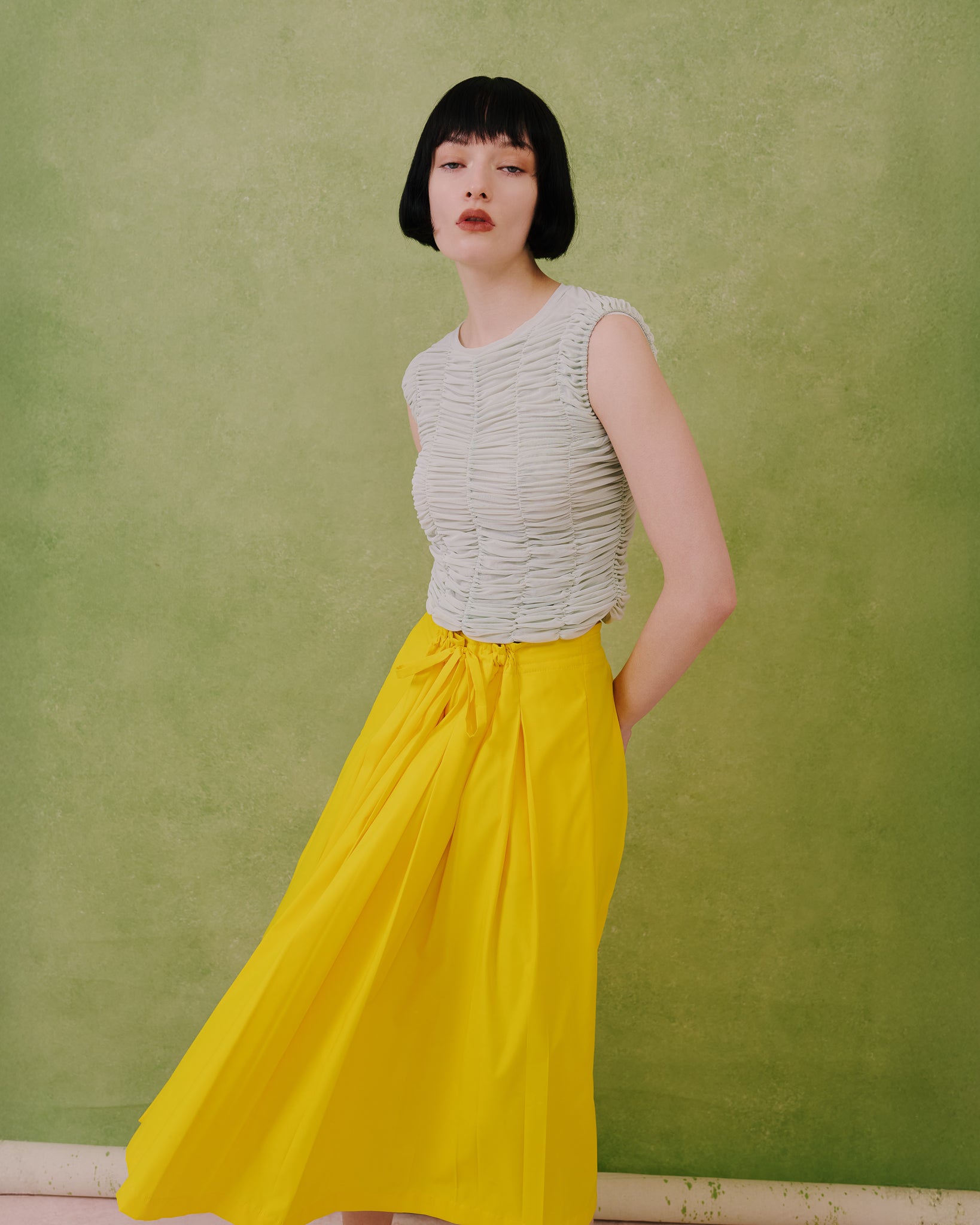 Model wears the Amelia Toro ruched tulle sleeveless top in mint with a yellow skirt