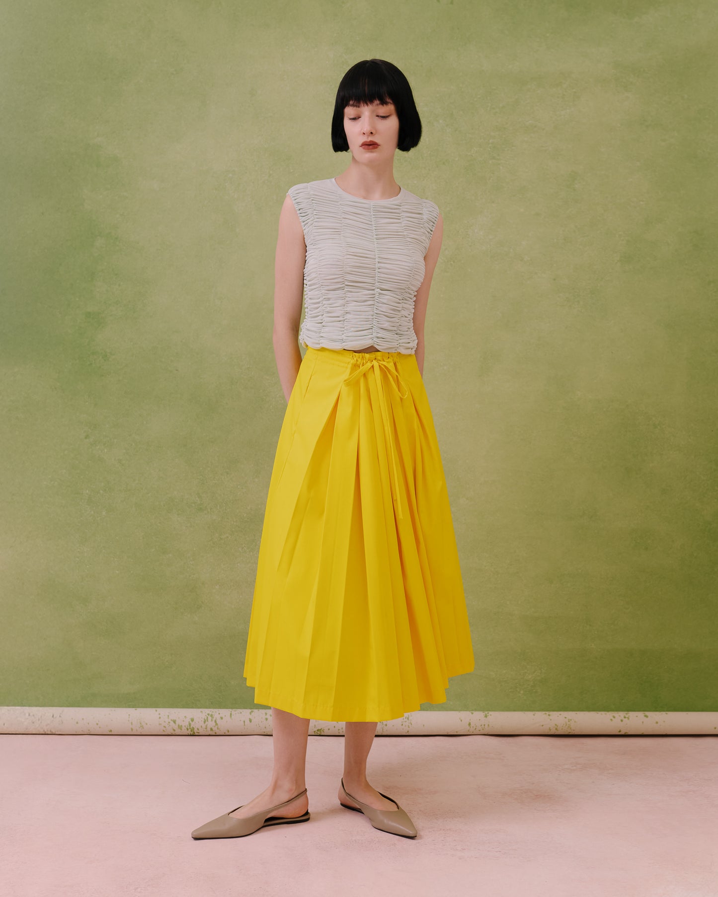 Model wears the Amelia Toro ruched tulle sleeveless top in mint, styled with a yellow skirt, front view