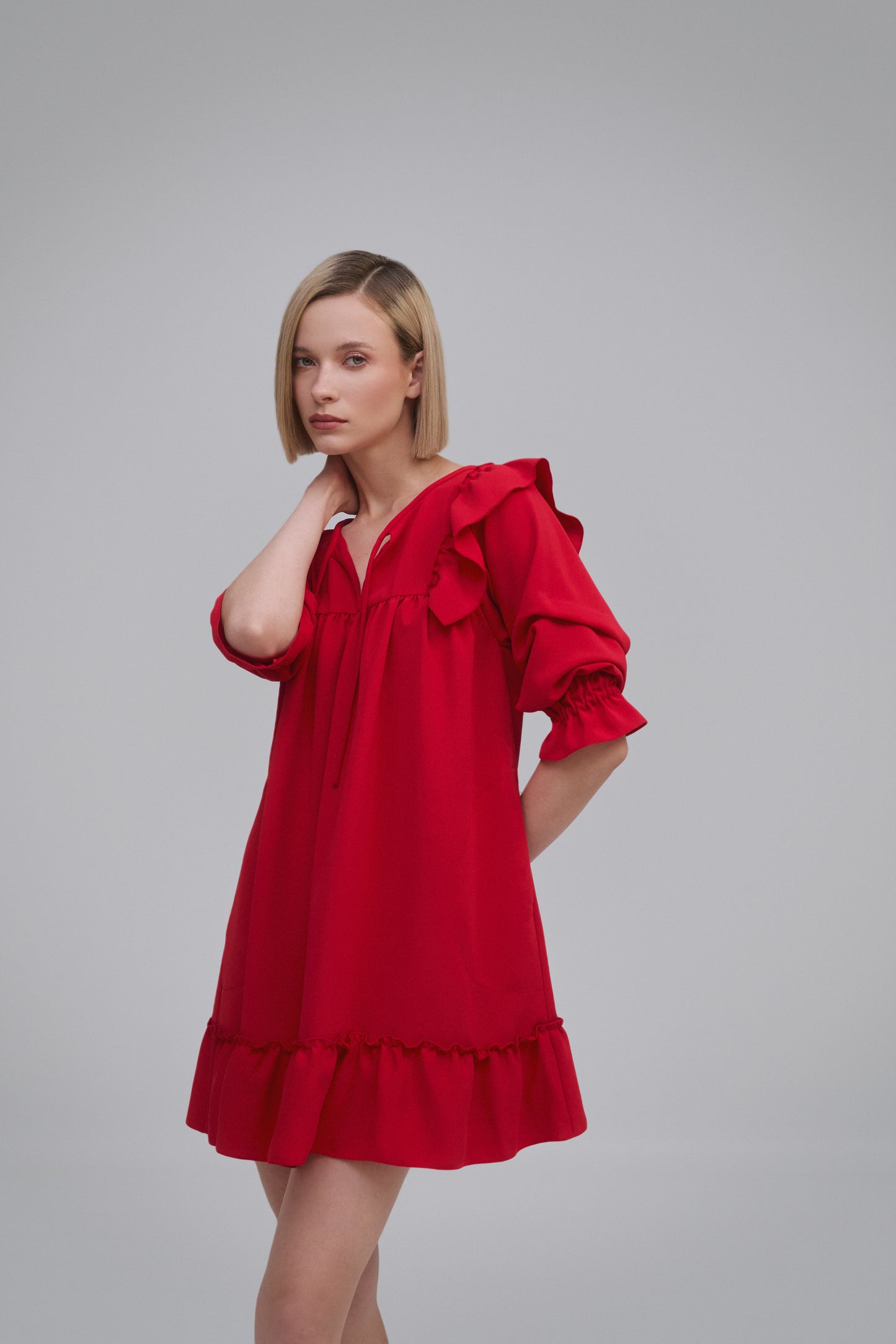 Model wears the Amelia Toro Ruffled Short-Sleeve Mini Dress in Red, front view