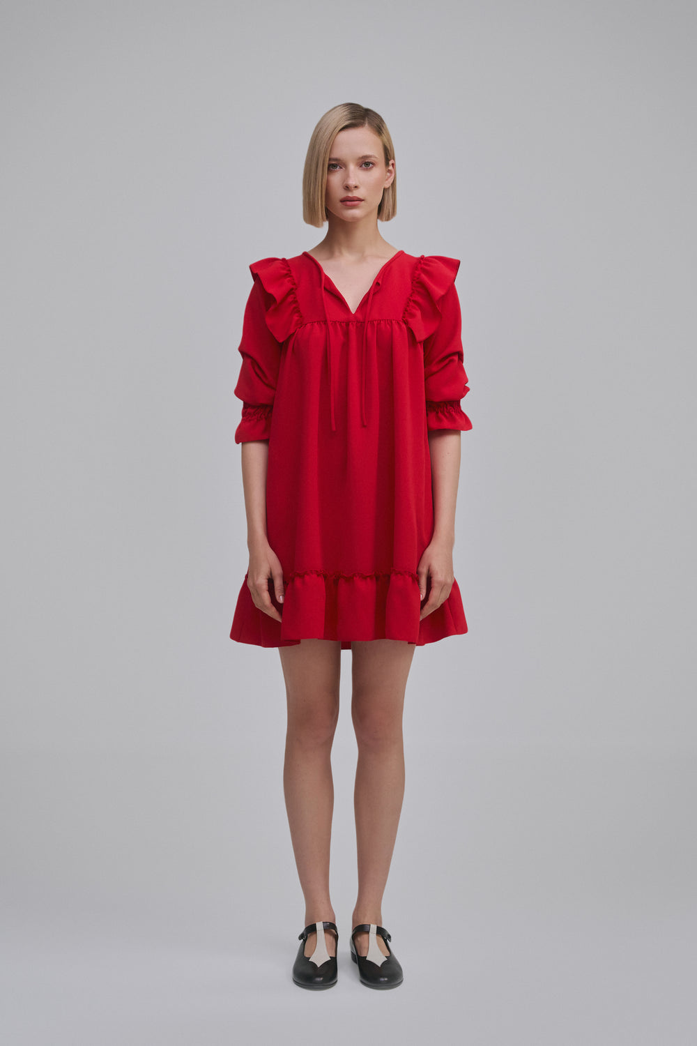 Model wears the Amelia Toro Ruffled Short-Sleeve Mini Dress in Red, front view