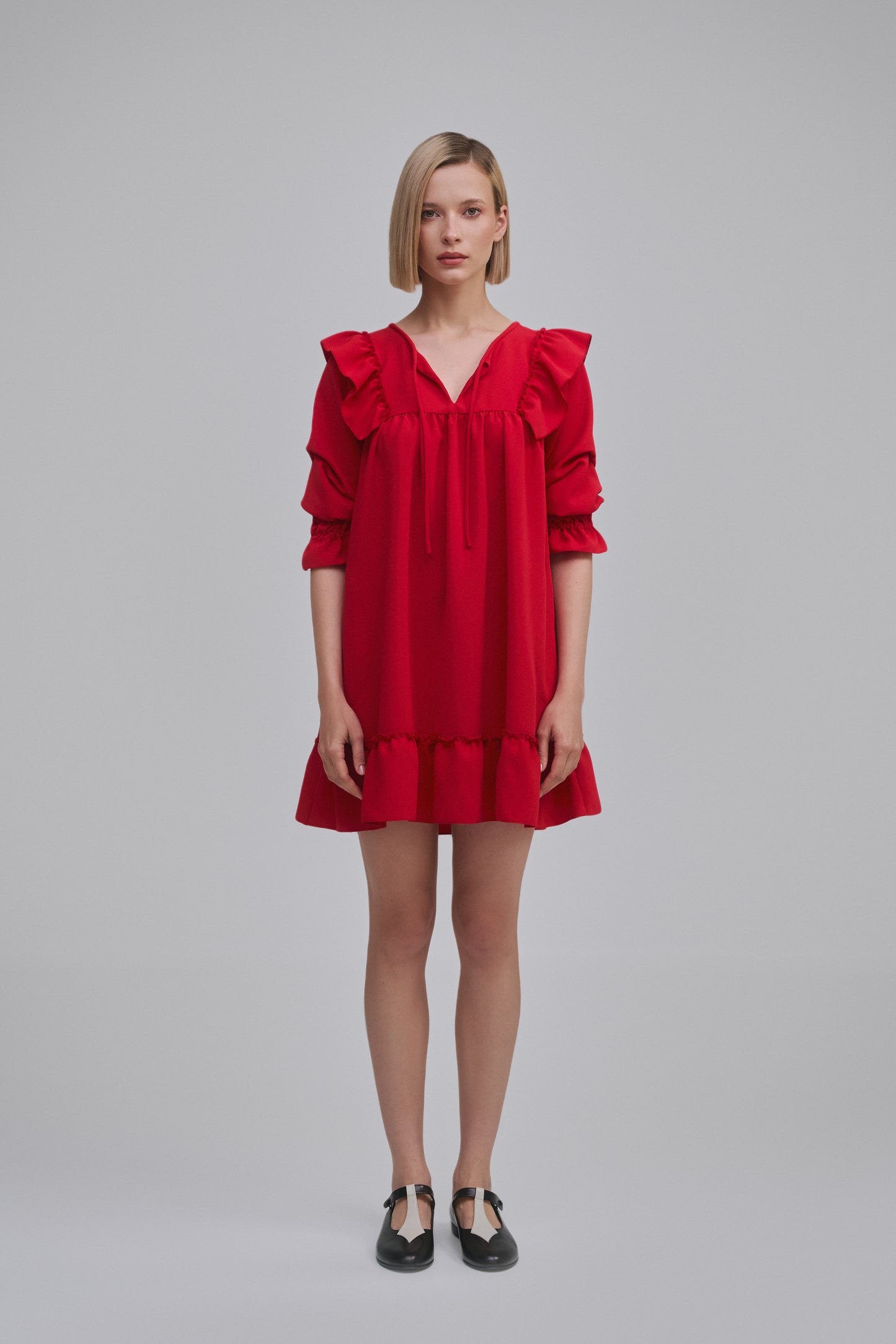Model wears the Amelia Toro Ruffled Short-Sleeve Mini Dress in Red, front view
