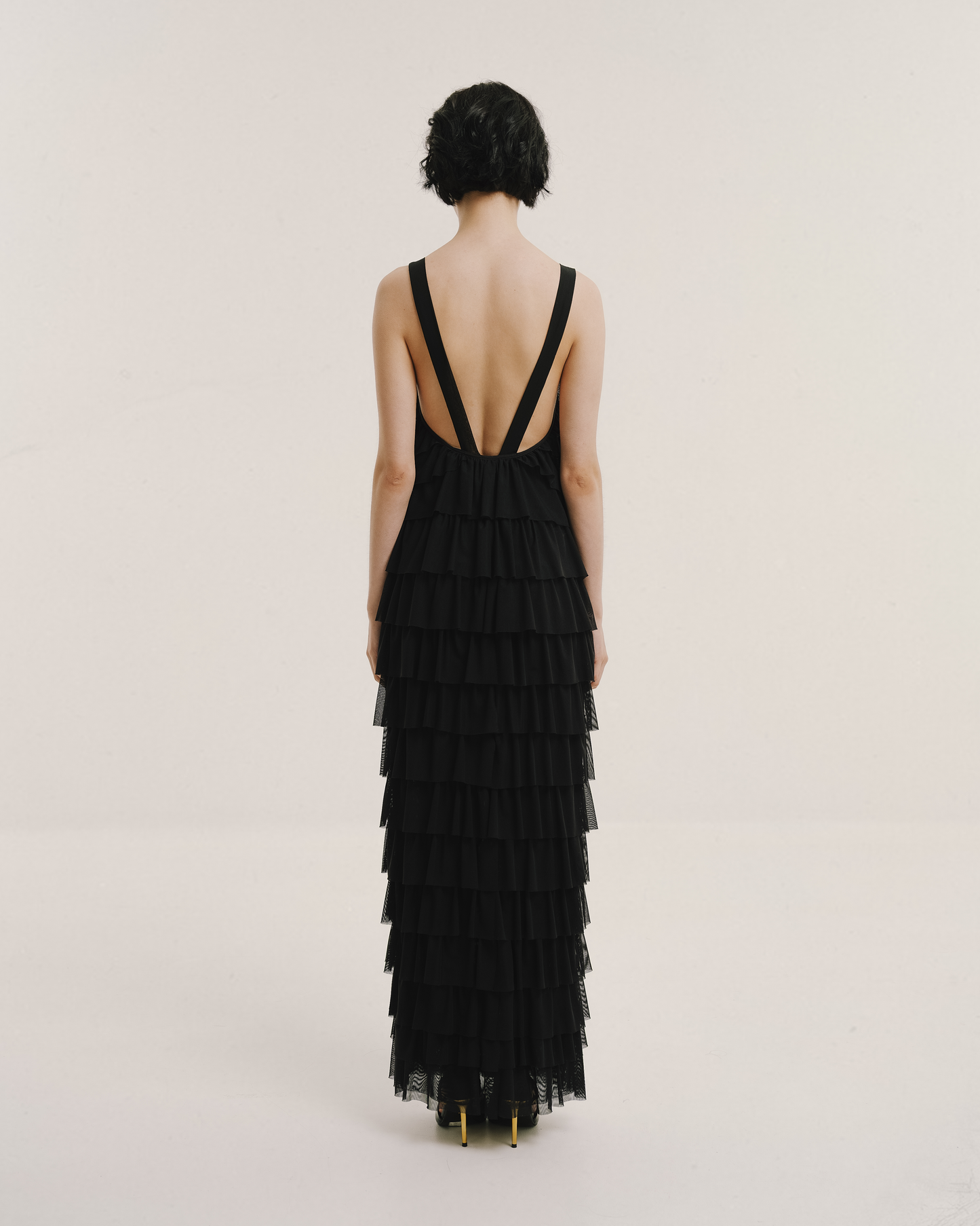 Model wears the Amelia Toro Ruffled Tulle Evening Gown in black, front view