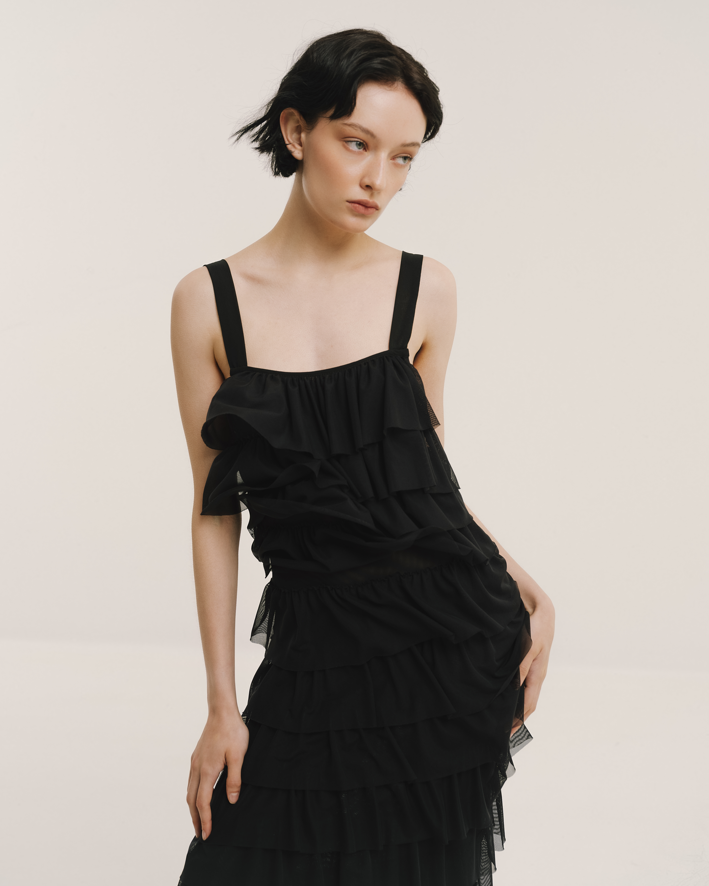 Model wears the Amelia Toro Ruffled Tulle Evening Gown in black, front view