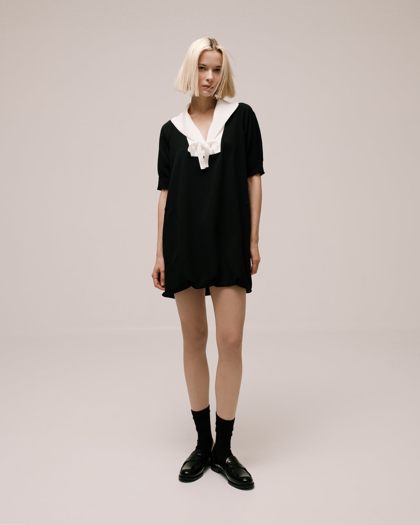 Model wears the Amelia Toro Sailor-Collar Cady Mini Dress in Black, front view
