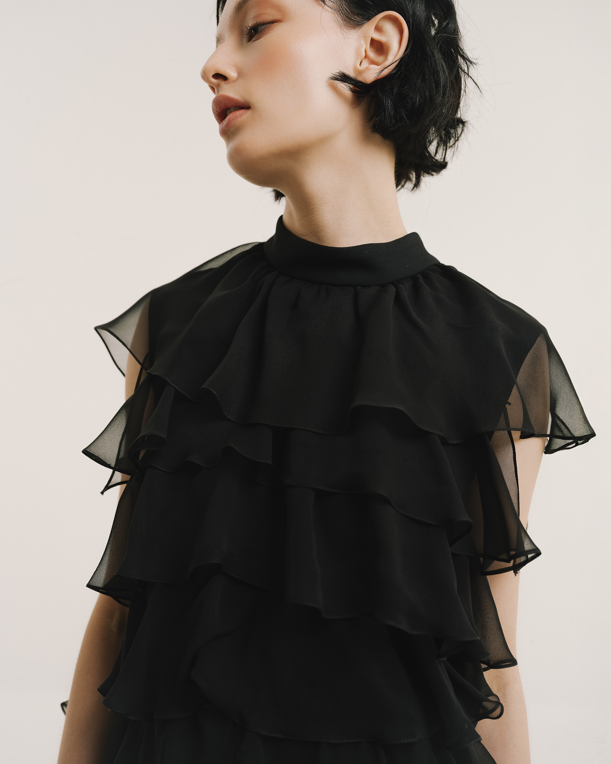 Model wears the Amelia Toro Silk Chiffon Tiered Ruffle Mini Dress in black, front view
