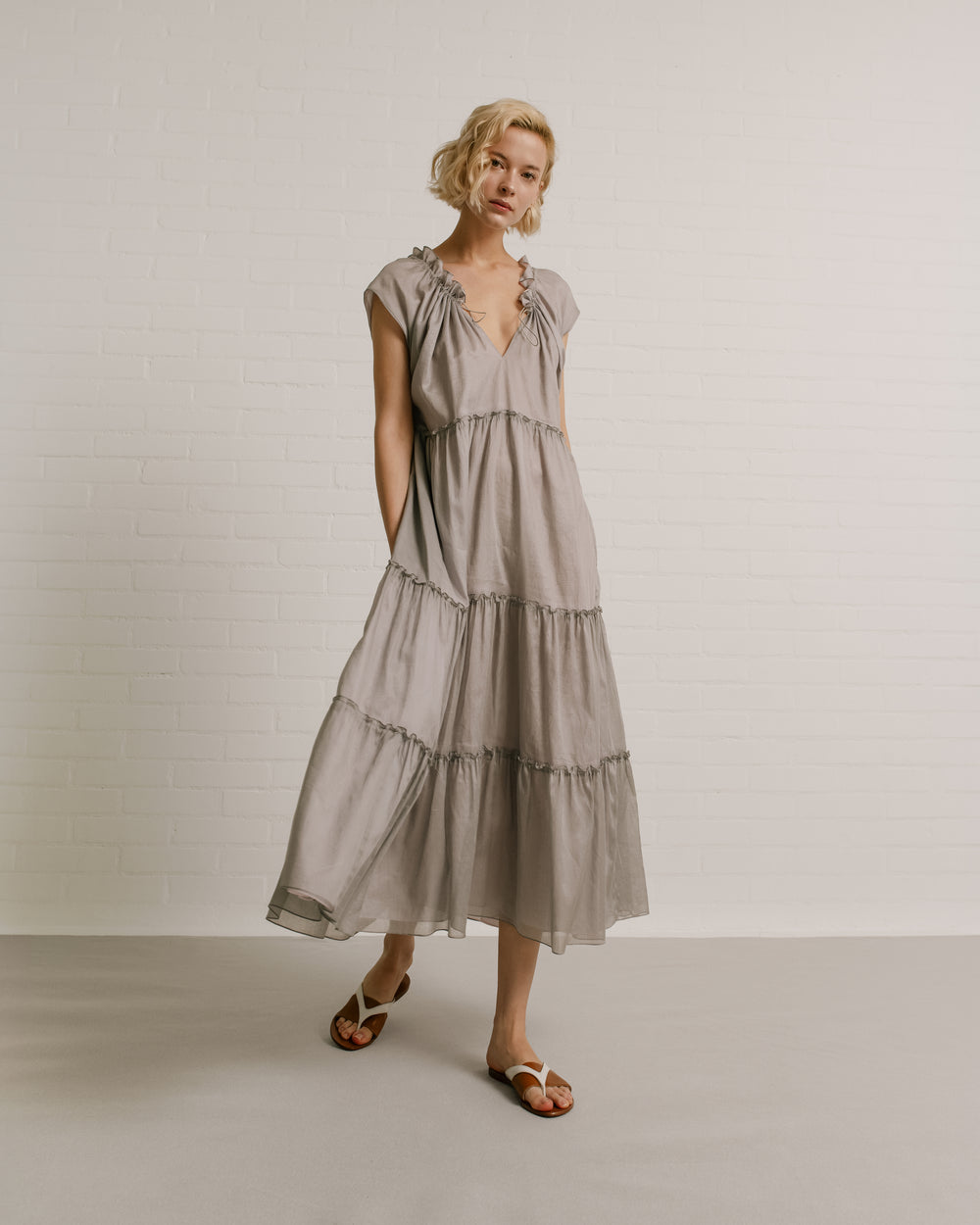 Model wears the Amelia Toro Sleeveless Ruffled Cotton Voile Midi Dress in Grey/Pink, front view