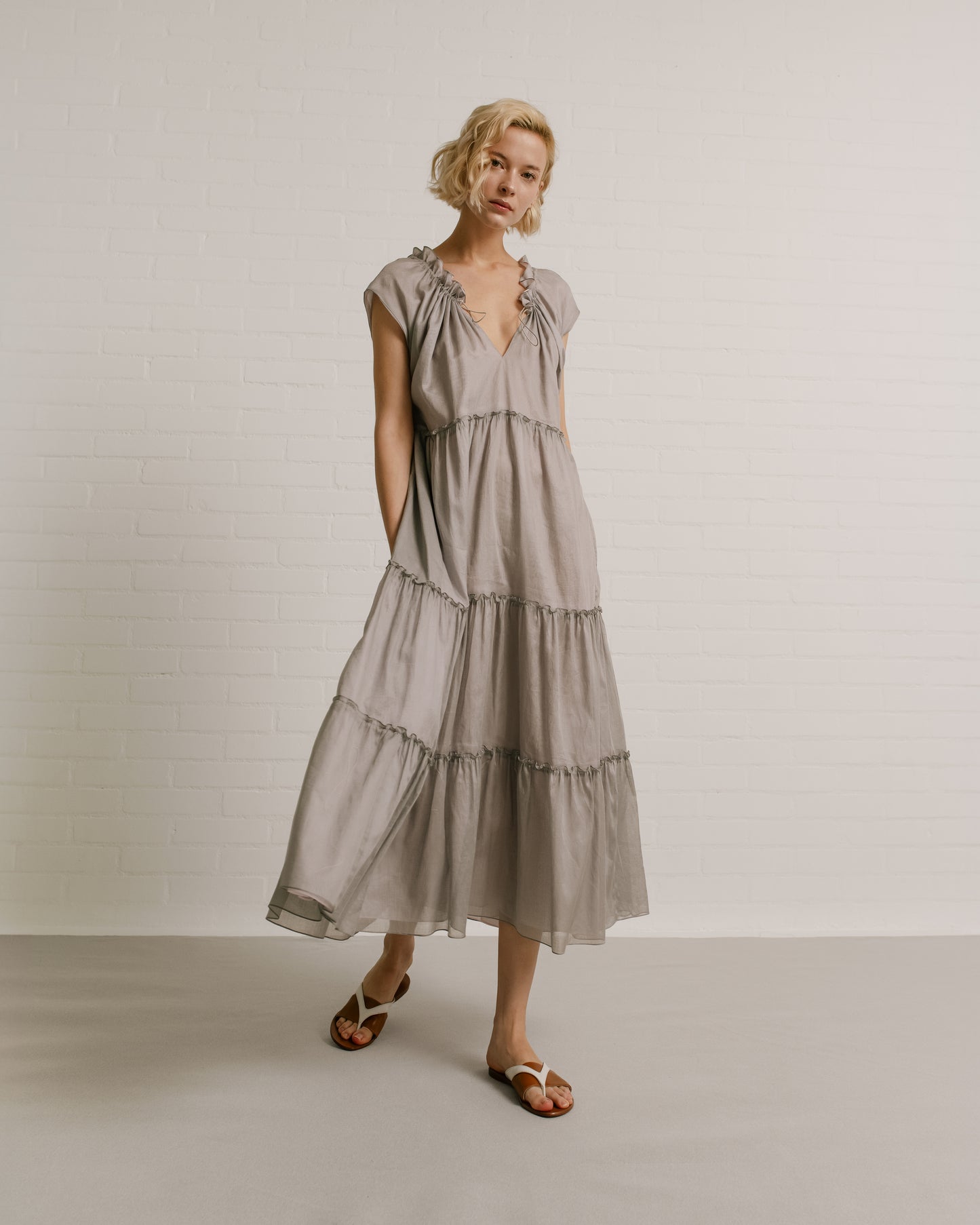 Model wears the Amelia Toro Sleeveless Ruffled Cotton Voile Midi Dress in Grey/Pink, front view