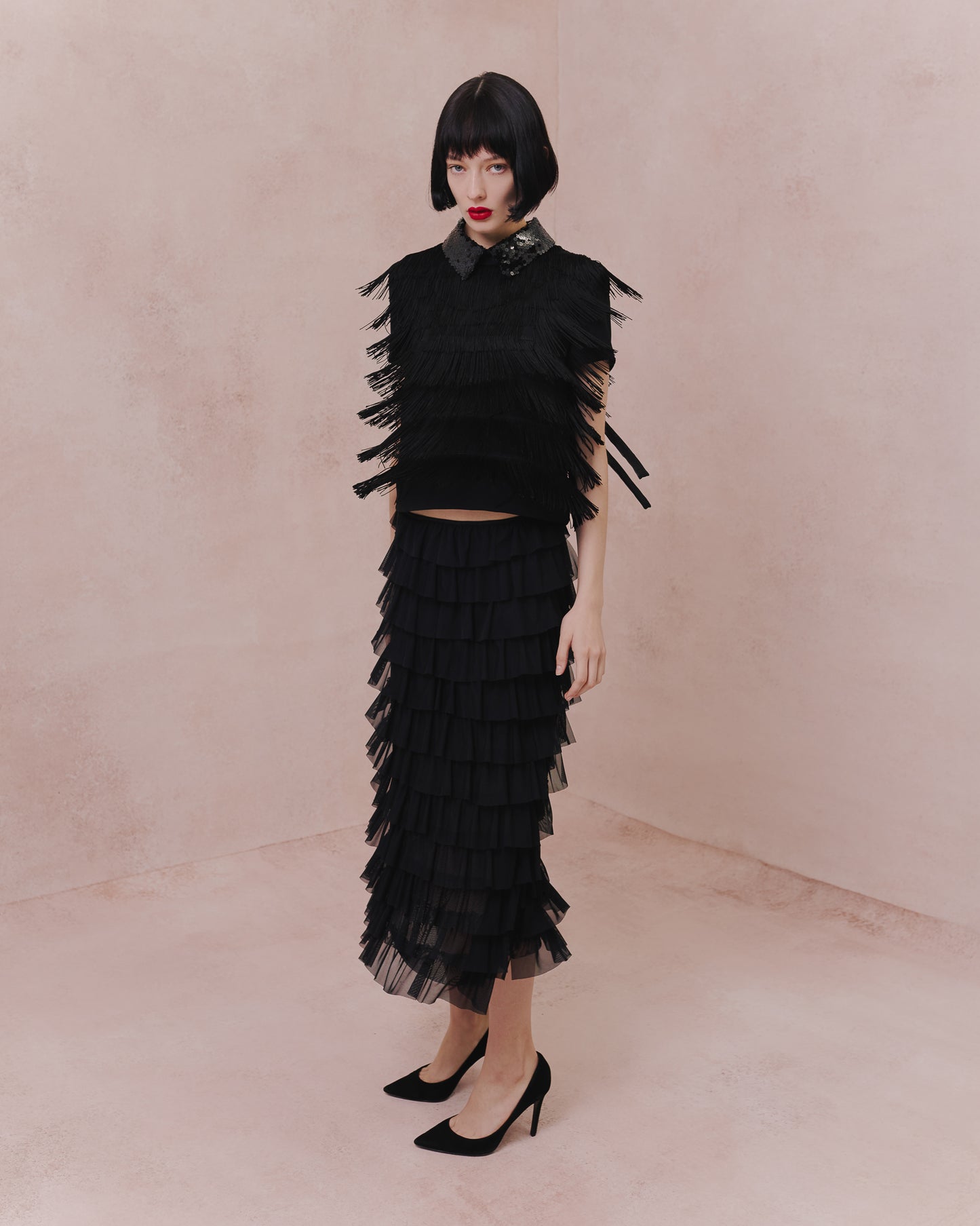 Model wears the Amelia Toro Tiered Ruffle Tulle Maxi Skirt in red, front view