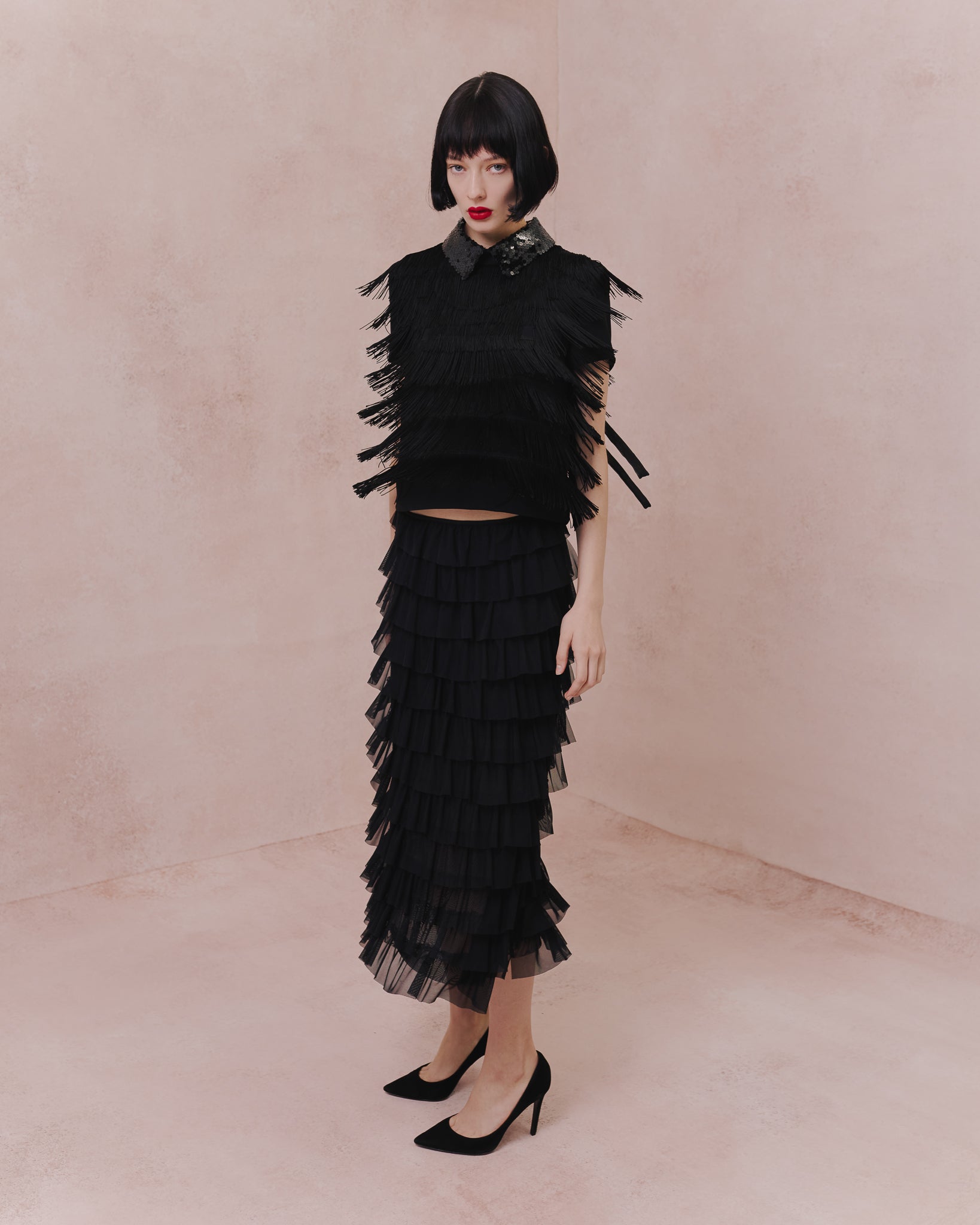 Model wears the Amelia Toro Tiered Ruffle Tulle Maxi Skirt in red, front view