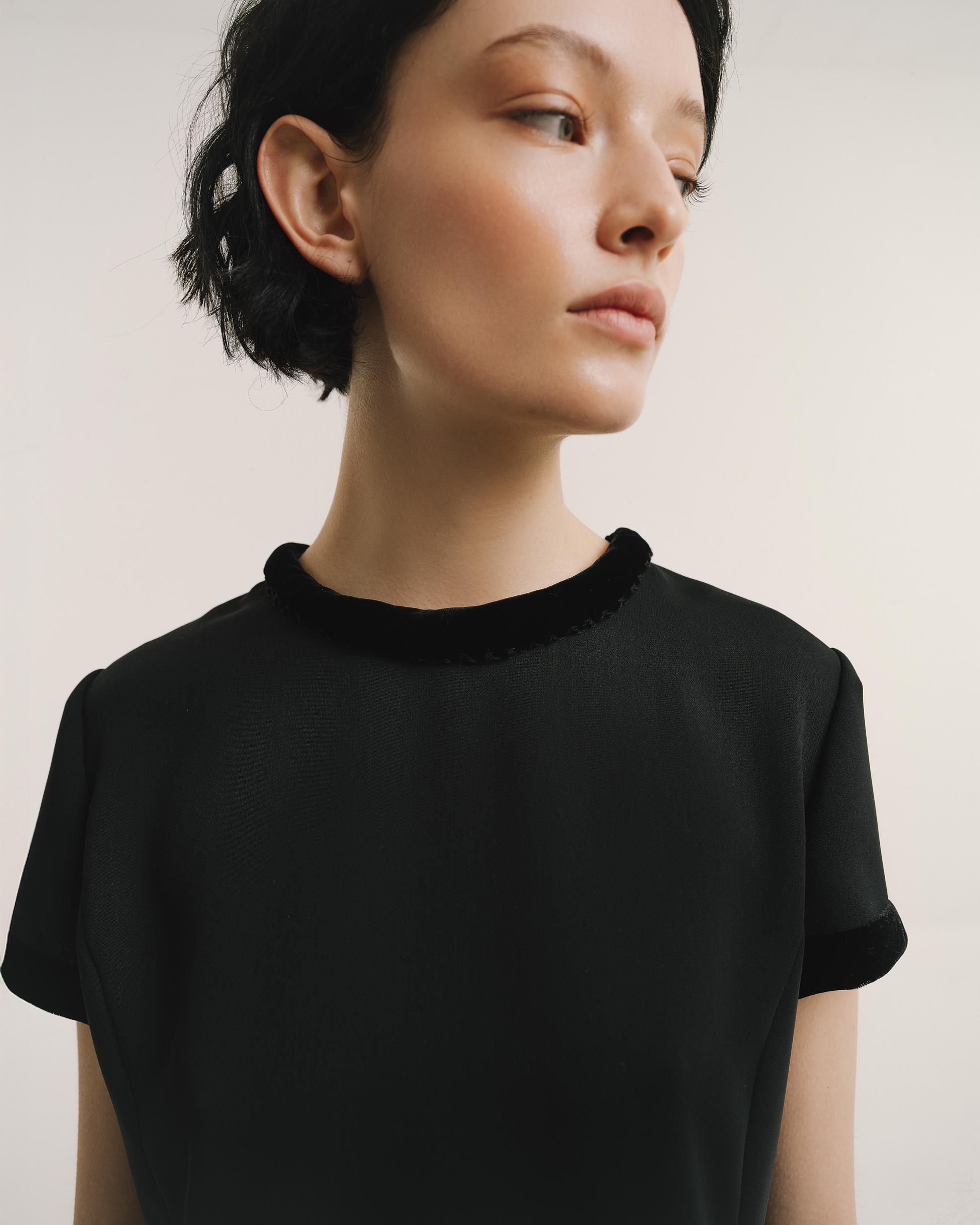 Model wears the Amelia Toro Velvet-Trimmed Little Black Dress in black, front view