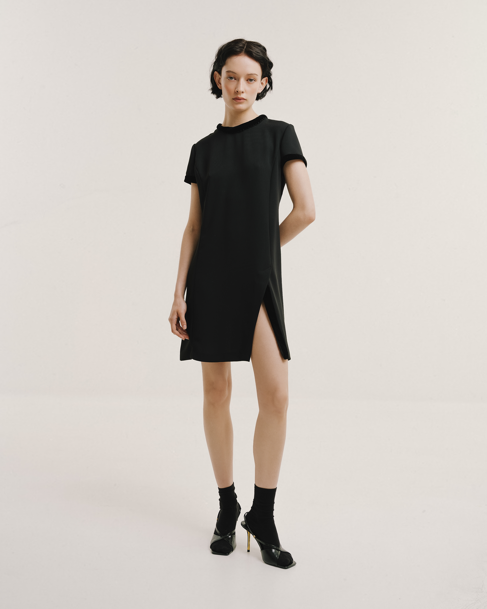 Model wears the Amelia Toro Velvet-Trimmed Little Black Dress in black, front view