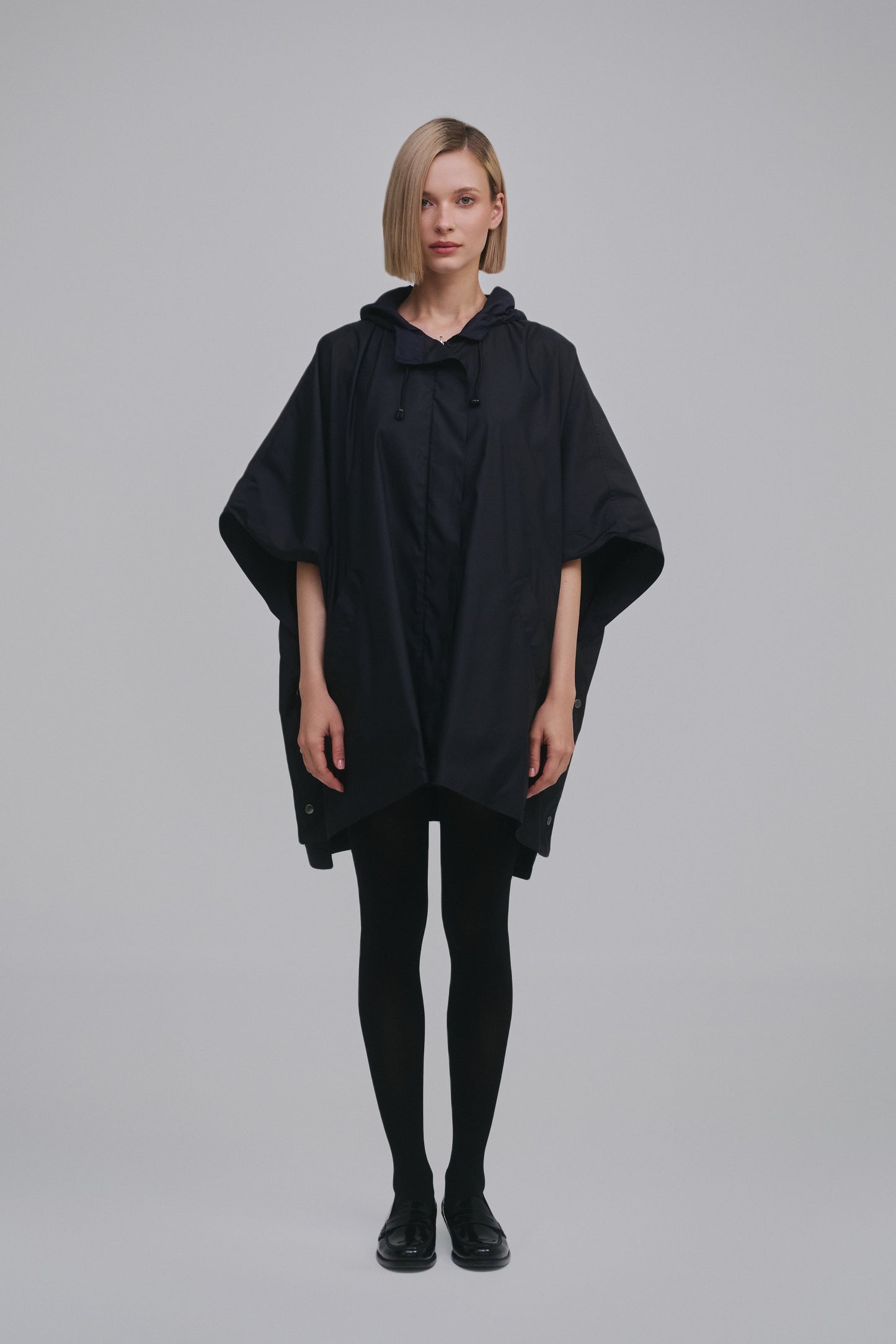 Model wears the Amelia Toro Water-Repellent Hooded Poncho in Black, front view