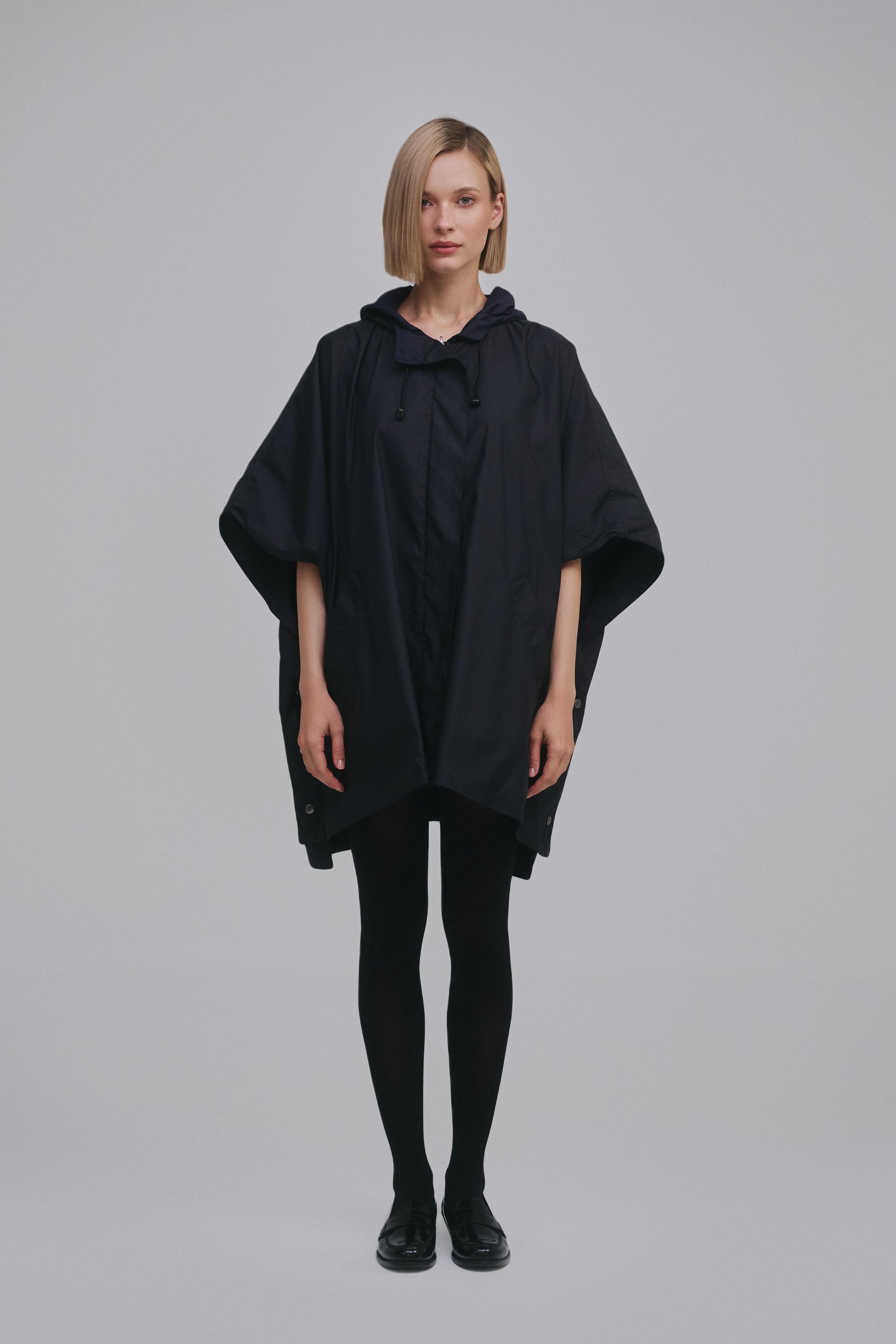 Model wears the Amelia Toro Water-Repellent Hooded Poncho in Black, front view