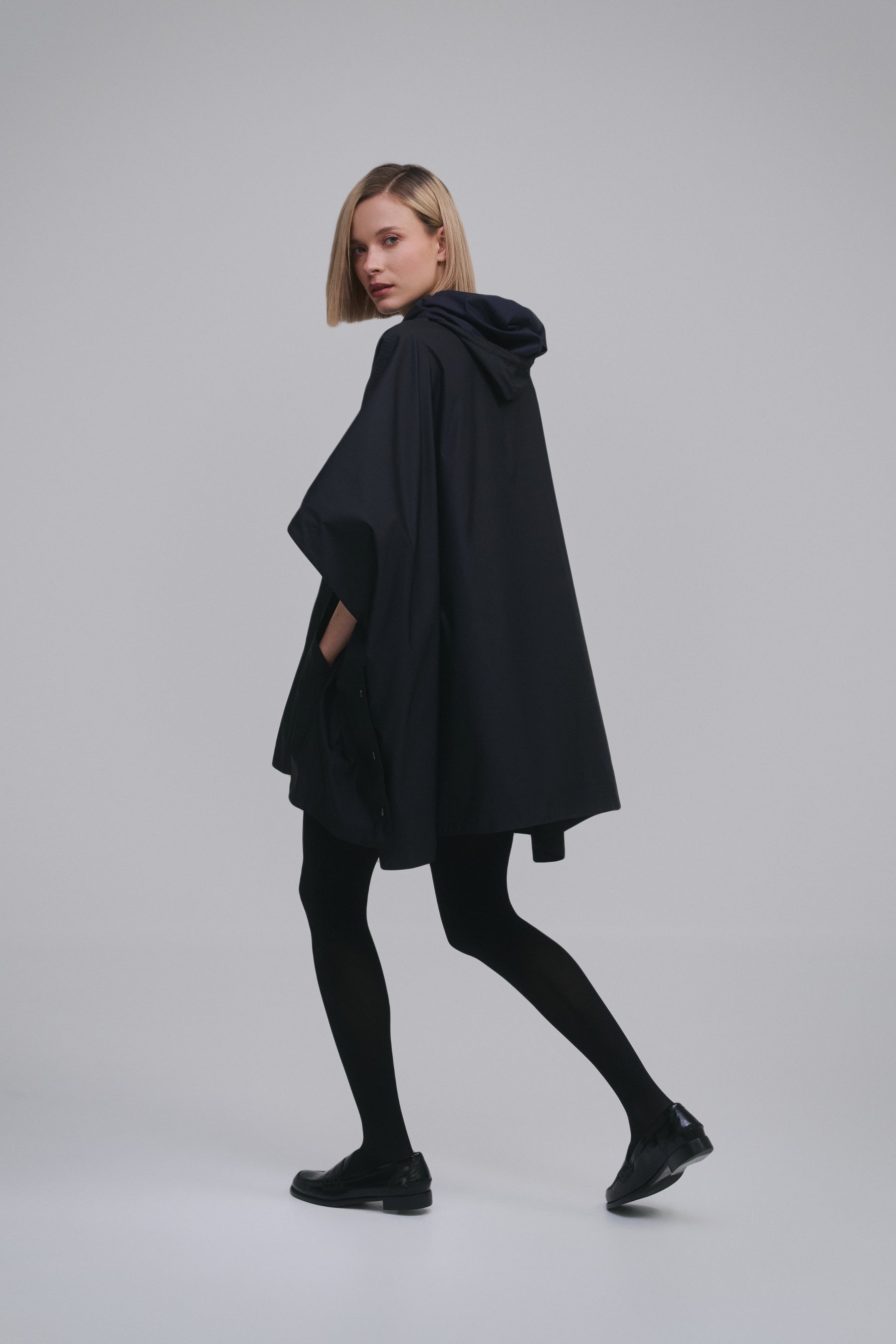 Model wears the Amelia Toro Water-Repellent Hooded Poncho in Black, front view