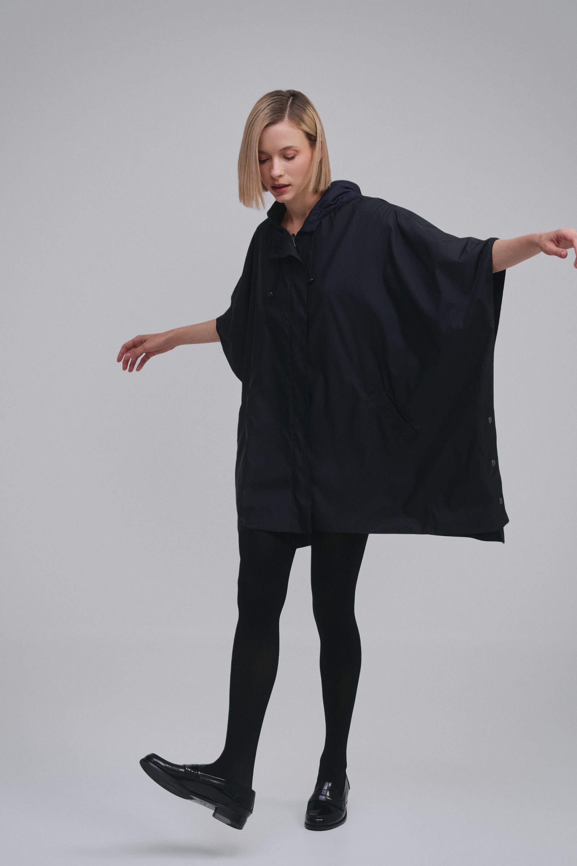 Model wears the Amelia Toro Water-Repellent Hooded Poncho in Black, front view